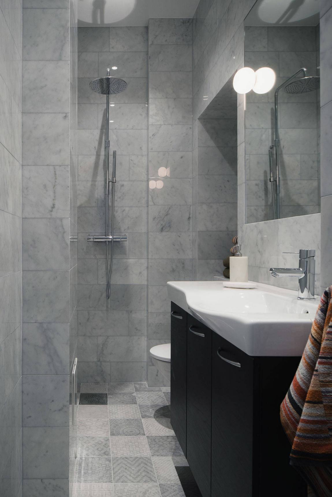 Phòng tắm có thiết kế tối giản từ màu sắc đến nội thất, từ vật liệu gạch ốp lát đến tấm gương kết hợp đèn chiếu sáng đều góp phần giúp không gian trông rộng rãi hơn.