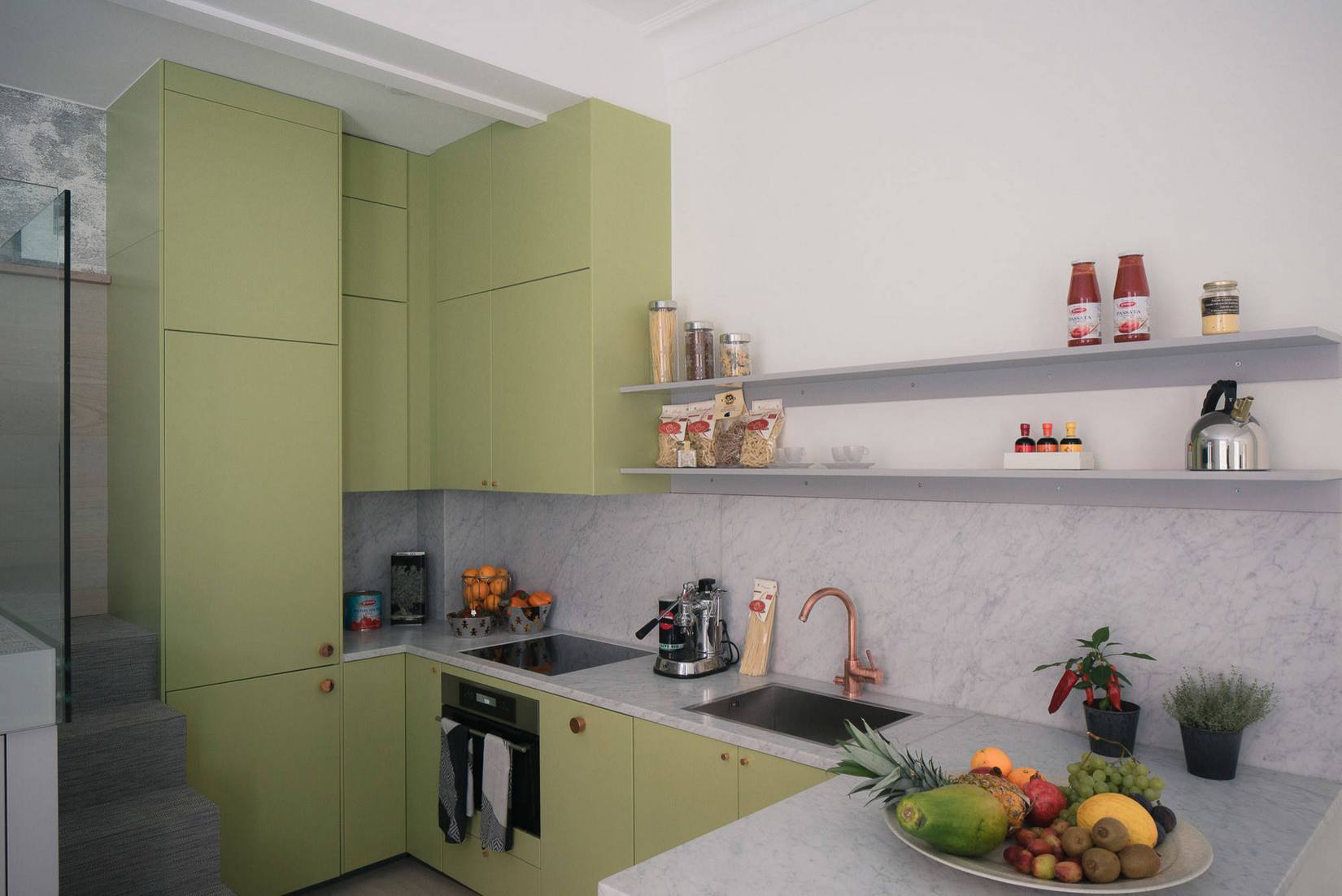 Gam màu ô liu được lựa chọn cho màu sơn tủ bếp, kết hợp đá cẩm thạch ốp mặt bàn và khu vực backsplash tạo nên vẻ đẹp sang trọng.