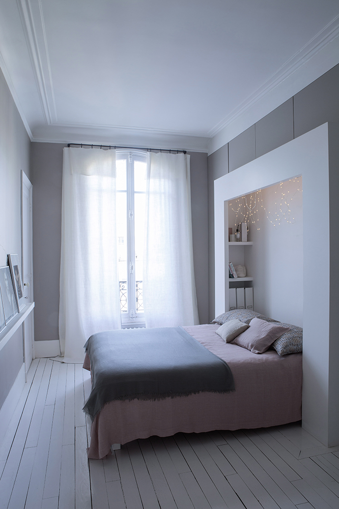 Một đầu giường hữu ích, kết hợp kệ mở lưu trữ ở 2 góc nhỏ của bức tường cùng những dây đèn LED ấm áp.
