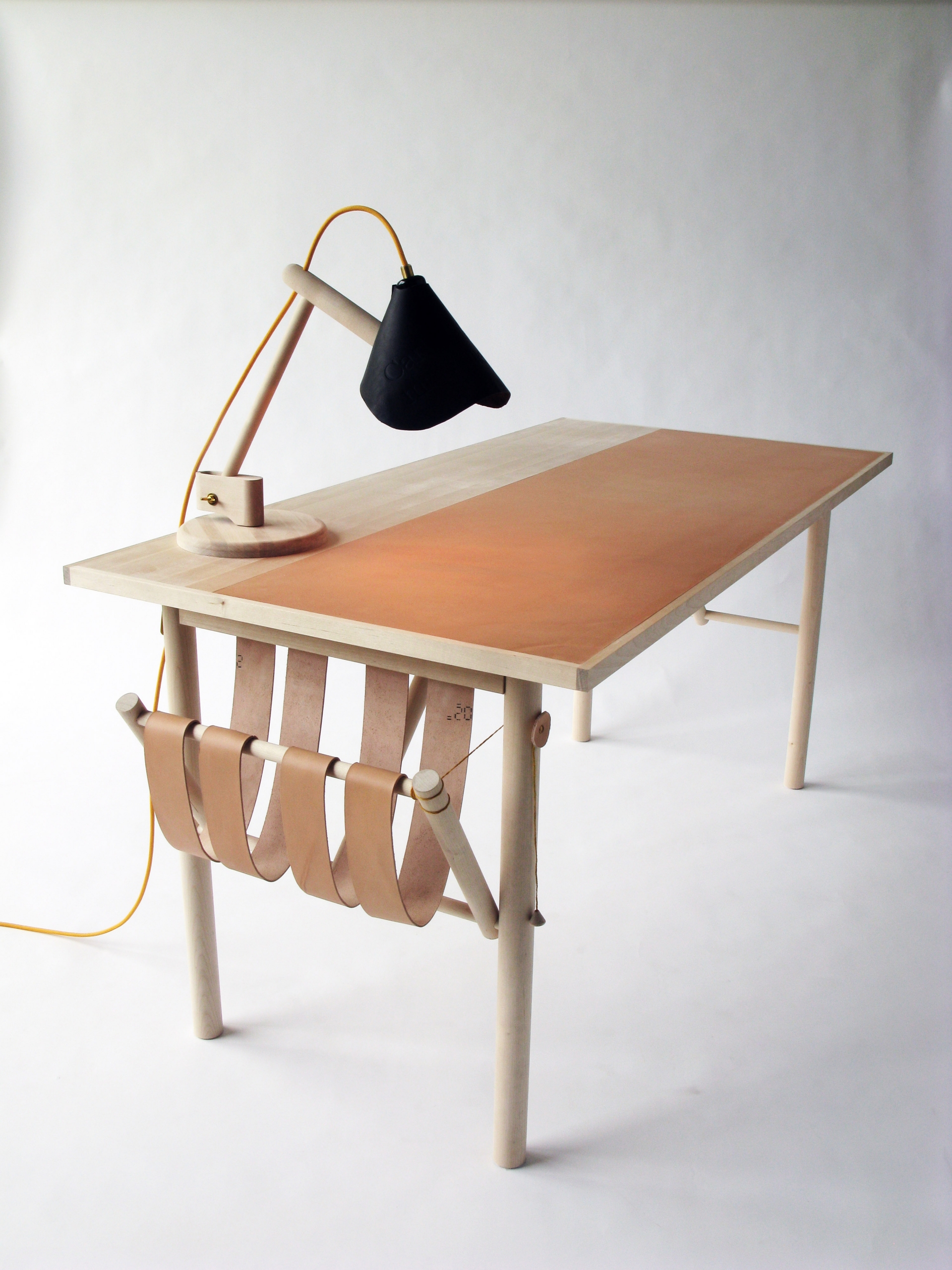 Một thiết kế tựa như 'chiếc võng' với khung bằng gỗ và các tấm giả da mềm mại màu nâu cố định vào cạnh bàn.