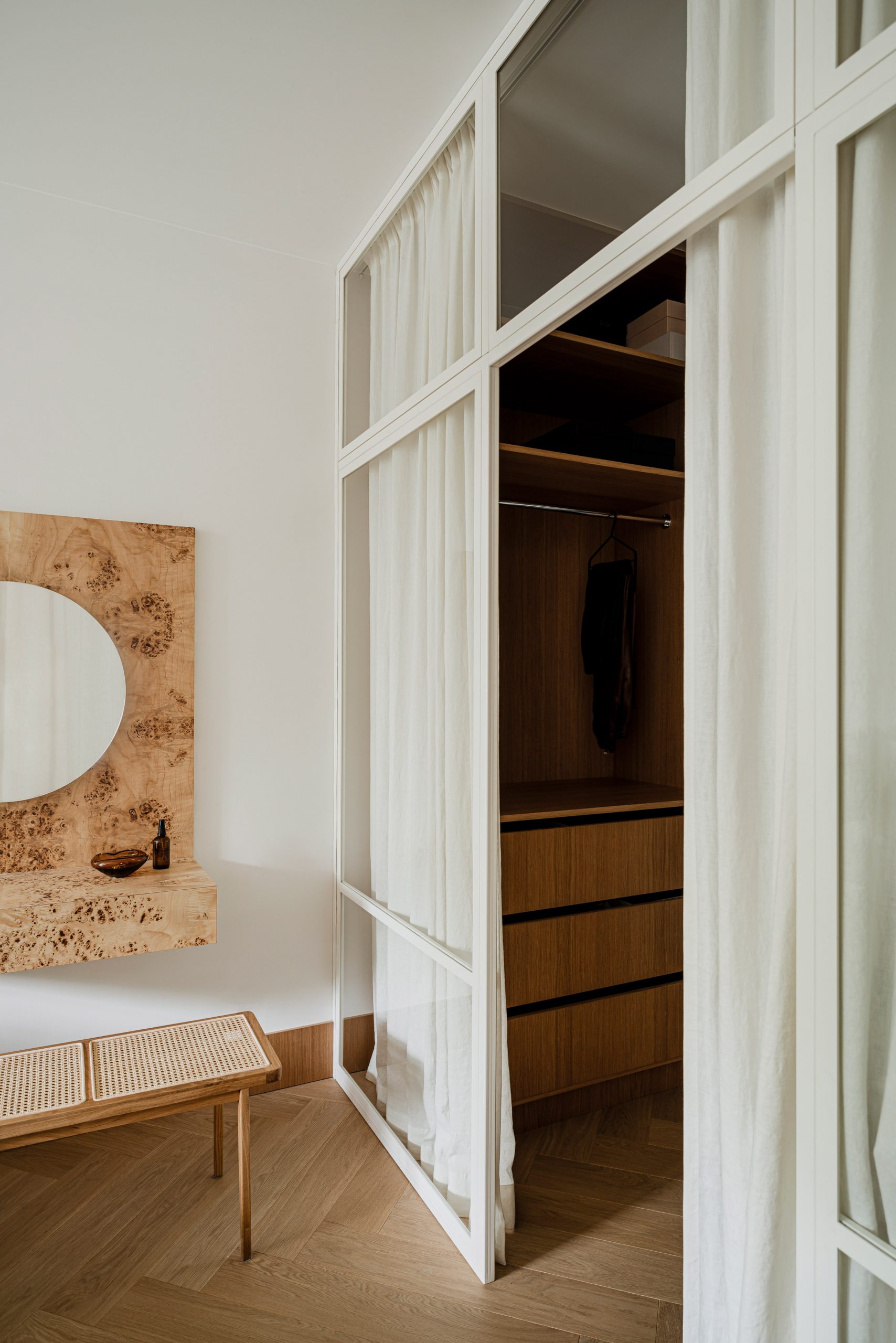 NTK Agnieszka Owsiany đã thiết kế căn hộ yên tĩnh, nhẹ nhàng cho cặp vợ chồng son với nội thất hầu như toàn bằng gỗ. Phòng ngủ được phân vùng bằng cửa kính chiều cao kịch trần, khung sơn trắng, tích hợp rèm che đồng màu để tạo sự riêng tư.