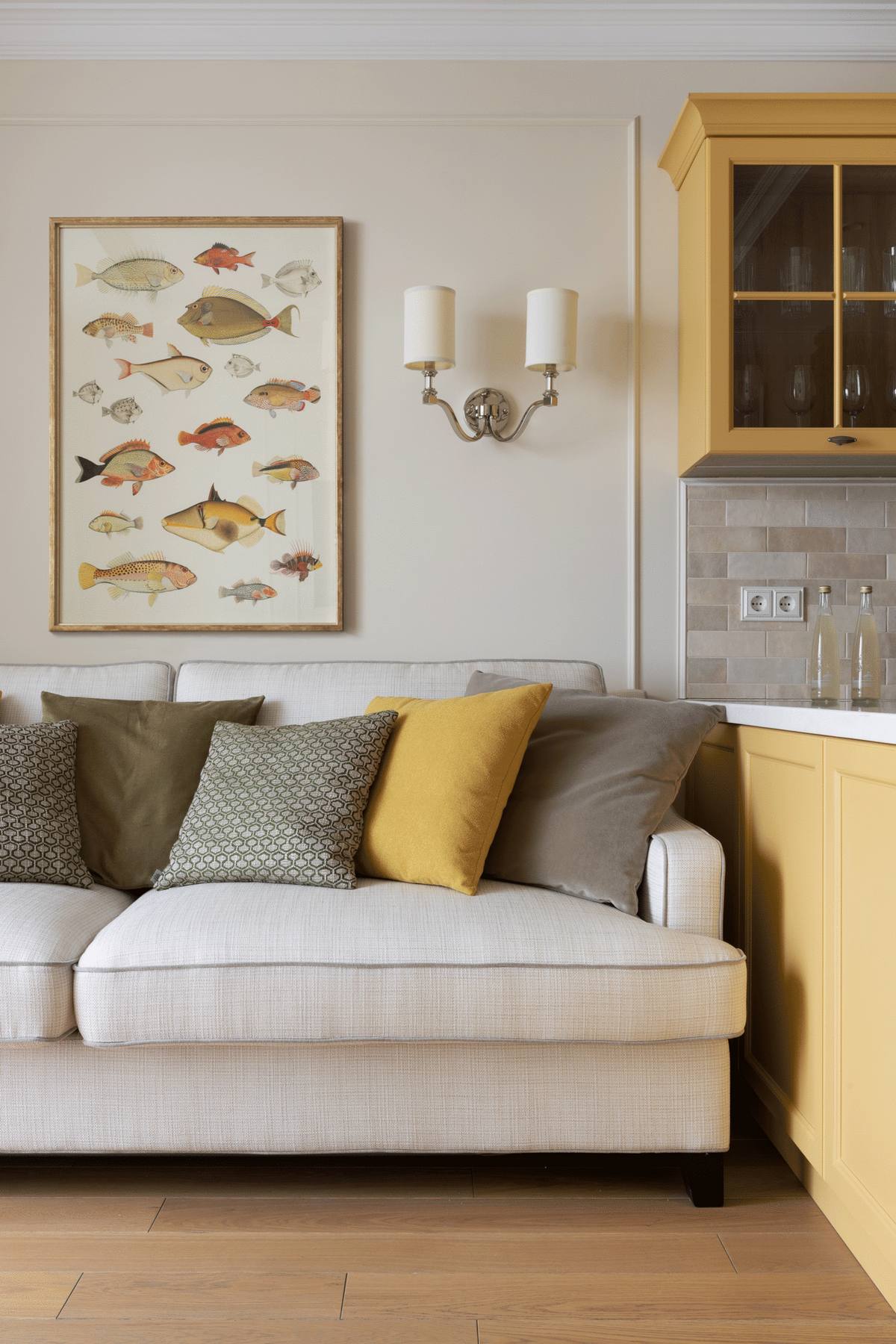 Bức tường phía sau sofa được trang trí bằng khung hình đủ loại cá - chủ đề này trông rất độc đáo và thú vị. Hai bên là đèn gắn tường đối xứng cân đối, hài hòa.