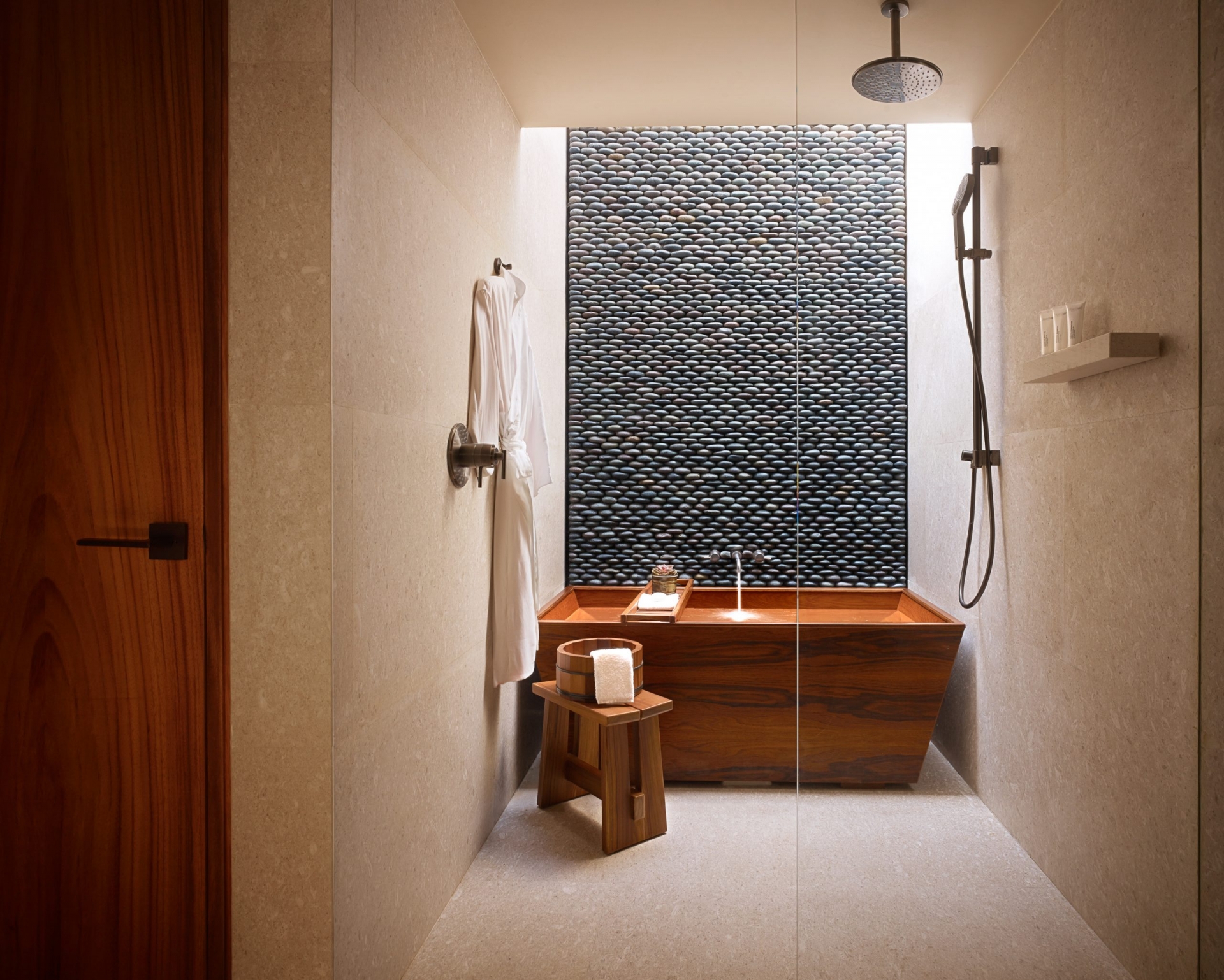 Và bây giờ sẽ là sự kết hợp của 3 vật liệu trong một không gian. Bao gồm gỗ cho bồn tắm và ghế ngồi kiểu Nhật, gạch lát sàn và ốp tường màu be, những viên đá cuội nhỏ gắn kết tạo nên vẻ đẹp độc đáo cho bức tường phòng tắm.