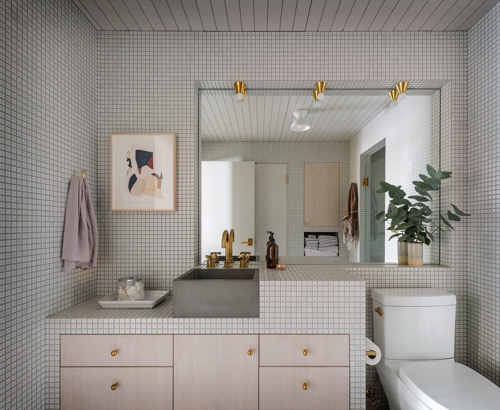 Nội thất phòng tắm với tường ốp gạch ô vuông nhỏ màu trắng, tủ lưu trữ gỗ núm kim loại mạ vàng đồng,... đều tạo sự liên kết nhất định với những khu vực chức năng còn lại.
