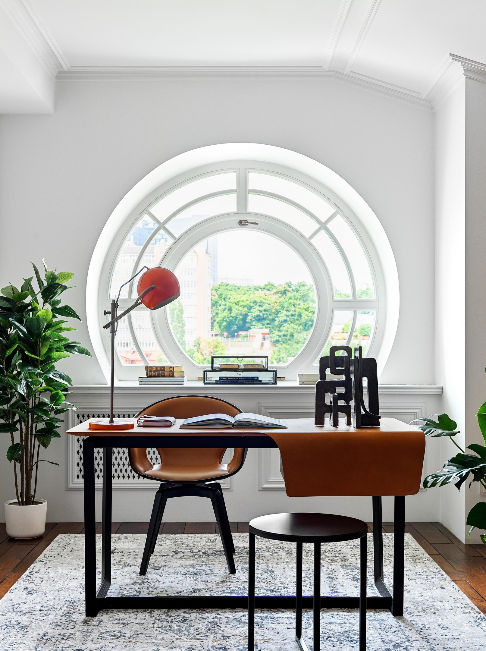 Phòng làm việc siêu đẹp với ô của hình tròn nhìn ra không gian bên ngoài tràn đầy cảm hứng. Bàn làm việc và ghế bành từ thương hiệu Poltrona Frau (Ý), chiếc đèn bàn cổ do Đức sản xuất từ những năm 60. Tất cả đều có màu cam gạch “tone sur tone” nổi bật.