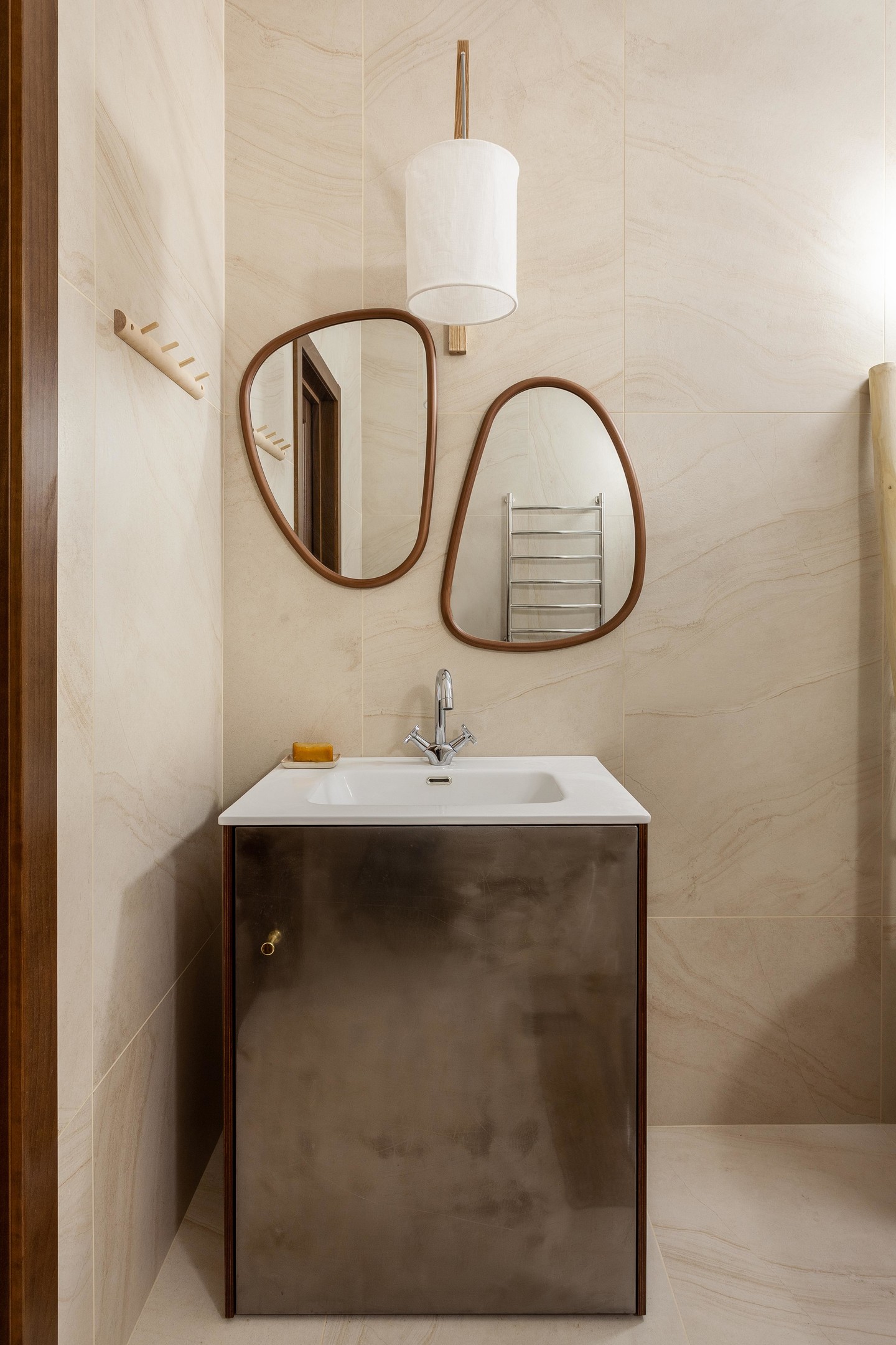 Phòng tắm dịu dàng tuyệt đối với gạch ốp tường và lát sàn màu be sang trọng. Hệ thống đèn chiếu sáng kết hợp với bộ đôi gương treo tường không chỉ để soi mà còn trang trí cho không gian thêm đẹp.