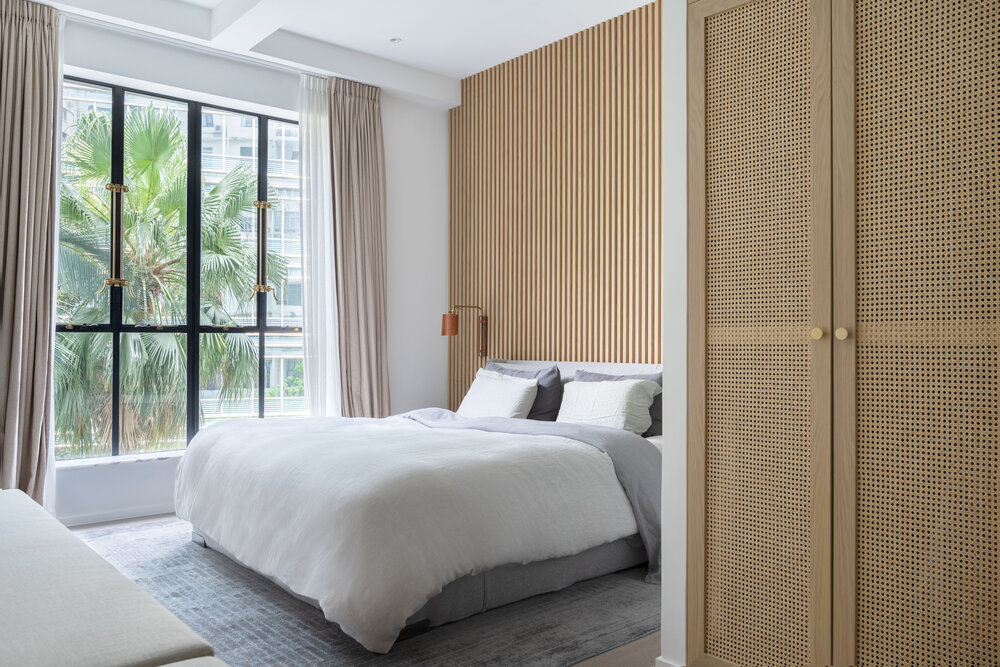 Lam gỗ tự nhiên sáng màu sử dụng ốp bức tường đầu giường ngủ tạo điểm nhấn nhẹ nhàng mà nổi bật giữa không gian lấy màu trắng làm chủ đạo. 