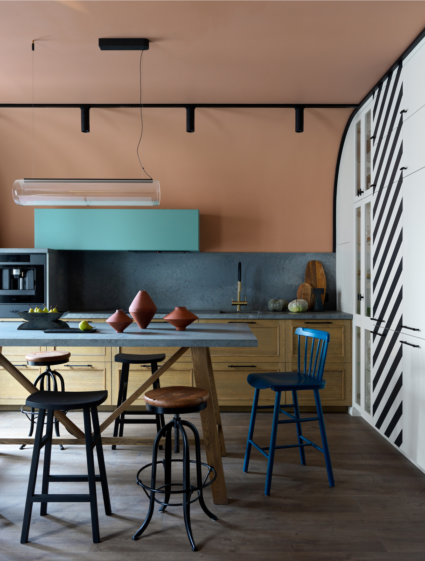 Phòng ăn được bố trí giữa phòng khách và phòng bếp, với chiếc bàn hình chữ nhật đơn giản nhưng xung quanh là những chiếc ghế đủ sắc màu và kiểu dáng tạo nên sự đa dạng, phá cách thay vì chọn bàn ghế đồng bộ.