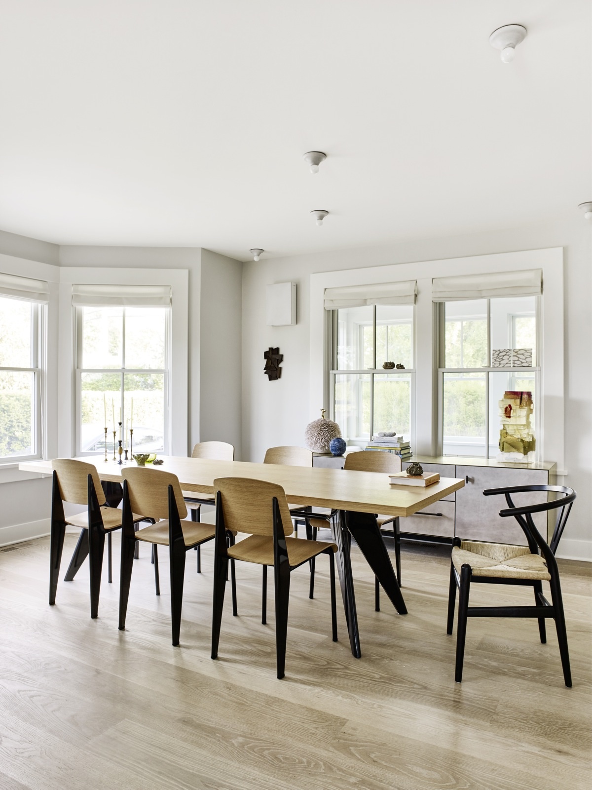 Tại phòng ăn, bộ bàn ghế gỗ phối màu đen tuyền sang trọng được thiết kế bởi  Jean Prouvé, riêng chiếc ghế khác biệt đặt ở đầu bàn ăn là của Hans Wegner. 