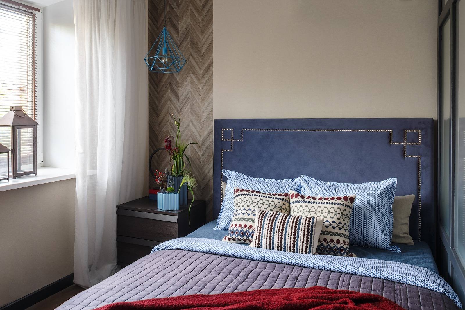 Phòng ngủ của người mẹ có thiết kế nổi bật, từ bức tường sơn màu be kết hợp gỗ hình xương cá sau táp đầu giường gỗ cho đến phần đầu giường màu xanh lam đậm, phối hợp bộ chăn ga gối dường như 'chẳng thiếu màu nào'.
