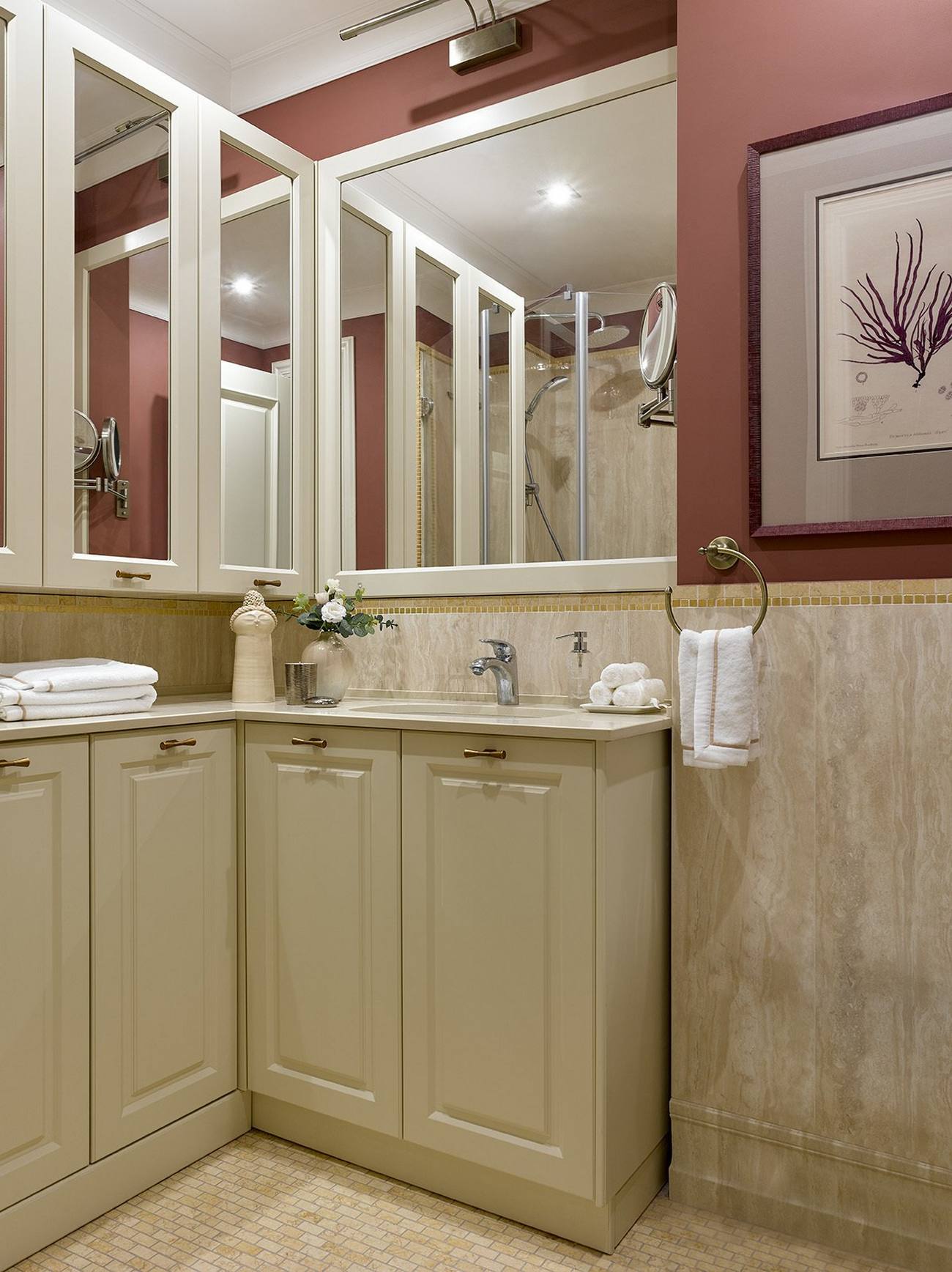 Phòng tắm với bảng màu khác biệt hoàn toàn, mang lại cảm giác ấm áp từ be nhạt cho đến màu đỏ mận ở nửa tường trên tạo điểm nhấn nổi bật. Những tấm gương lớn tiếp tục phát huy chức năng kỳ diệu của mình trong việc 'cơi nới' không gian nhỏ.