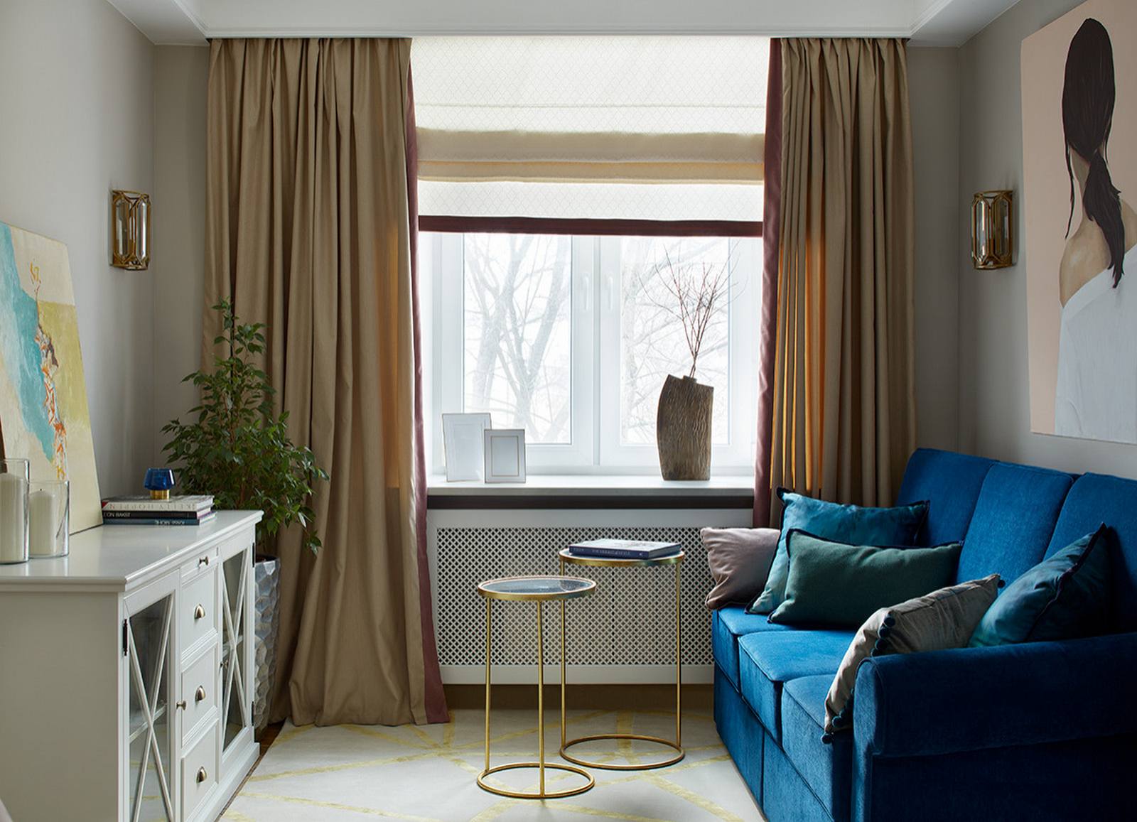 Phòng khách được bố trí bên cạnh ô cửa sổ lớn nhìn ra những hàng cây bên ngoài thật lãng mạn. Chiếc ghế sofa màu xanh làm đậm cùng 2 chiếc bàn nước cao thấp bằng kim loại mạ vàng đồng đơn giản nhưng tinh tế.