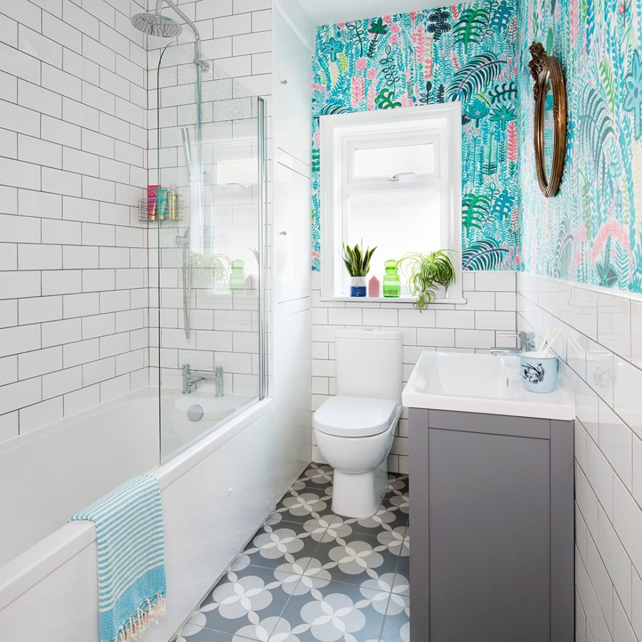 Phòng tắm ban đầu chỉ sử dụng tông màu trắng cho bức tường, điểm nhấn duy nhất là gạch bông lát sàn và tủ sơn xám nhạt. Chỉ cần sử dụng giấy dán cho nửa trên bức tường là cảm giác như cả bầu không khí tươi mát 'ùa' vào phòng tắm lúc Hè sang.