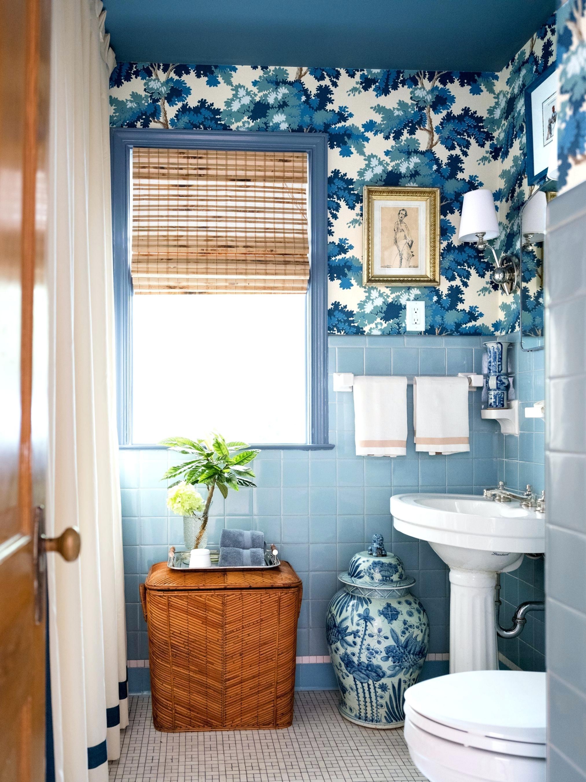 Sắc xanh lam đậm của giấy dán tường phối hợp cùng gạch ốp màu xanh lam nhạt thêm vào sự điểm tô của những món đồ bằng gốm sứ 'tone sur tone' tạo cho phòng tắm hiệu ứng thẩm mỹ vô cùng đẹp mắt.