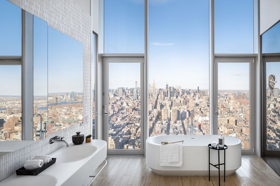Căn hộ hiện đại với phòng tắm thiết kế cửa kính trong suốt nhìn ra thành phố sôi động. Bức tường phía trên bồn rửa được ốp gương cỡ lớn càng làm tăng thêm sự thoáng đãng của không gian thư giãn.
