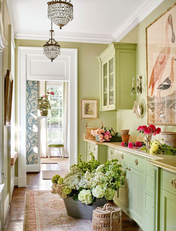 Phòng bếp tươi sáng cả một góc nhà với sơn tủ màu xanh lá cây tươi mát, kết hợp cùng rất nhiều loài hoa tươi đủ sắc màu, khiến bất cứ ai bước vào không gian này cũng cảm thấy nên thơ như một khu vườn thu nhỏ.