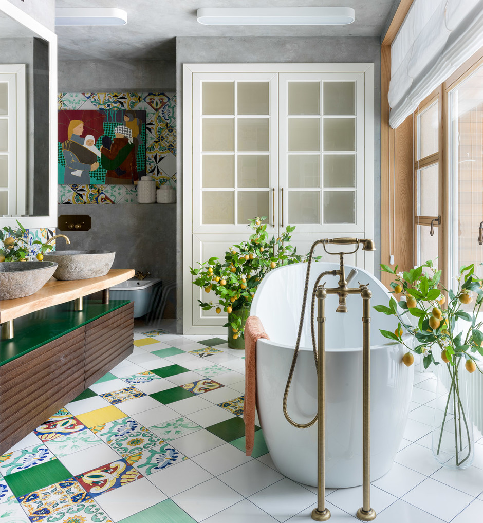 Rất nhiều sắc thái của gam màu xanh lá được sử dụng trong phòng tắm này. Những viên gạch bông xen kẽ nhiều họa tiết và màu sắc. Bề mặt tủ lưu trữ bên dưới bồn rửa, tranh treo tường cho đến những quả chanh vàng sau tán lá đều vô cùng sinh động.