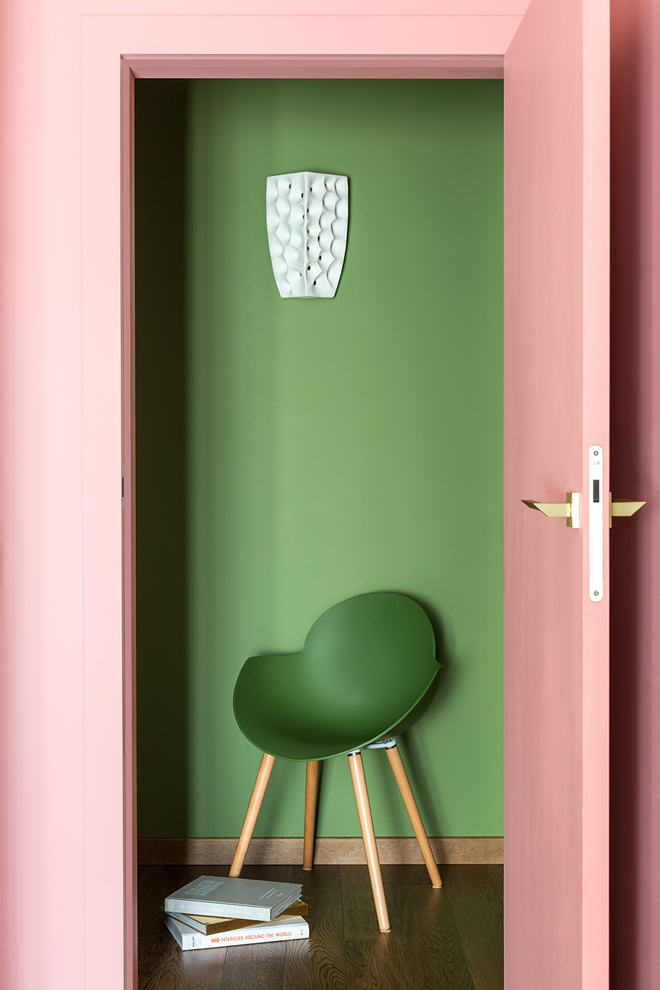 Cách đơn giản để phân vùng các khu vực bằng thị giác chính là sử dụng màu sắc. Ở căn hộ này, NTK nội thất đã chọn màu xanh lá để sơn tường và chiếc ghế xanh đánh dấu khu vực hành lang, kết hợp với sắc hồng điệu đà để tăng phần trẻ trung, nữ tính.