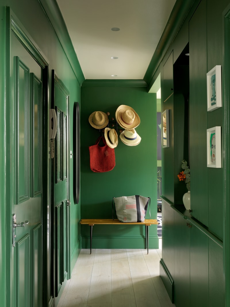 Chỉ cần nhìn hành lang này thôi cũng đủ thấy chủ nhân là 'fan cuồng' của màu xanh lá: Từ cửa ra vào, bức tường cho đến tủ lưu trữ cao kịch trần được 'ngụy trang' khéo léo. Sàn lát gỗ tự nhiên, phần trần sơn màu be tạo sự tương phản nhẹ nhàng cũng như 'kéo cao' trần nhà hơn thực tế.