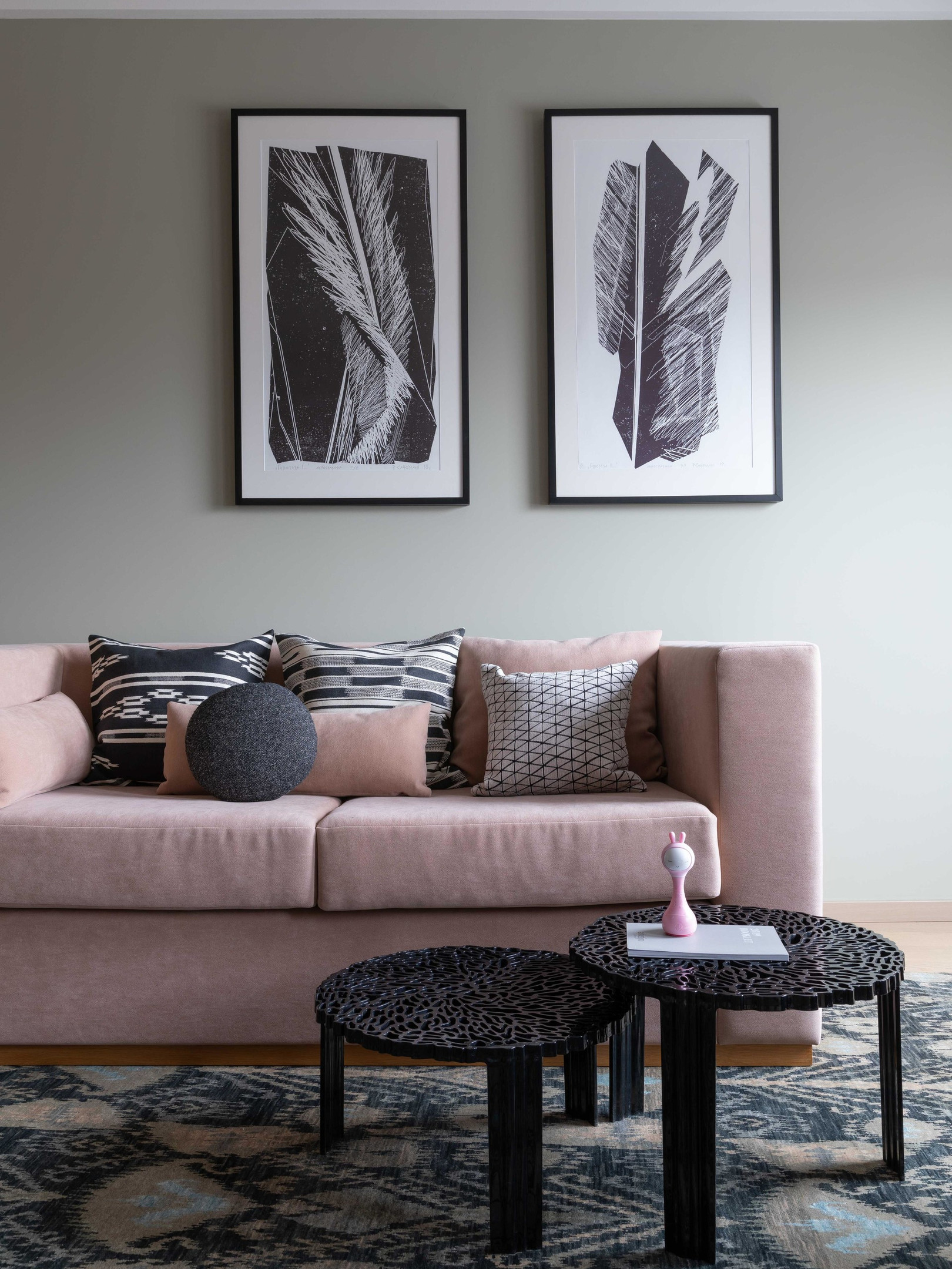Một khu vực tiếp khách phụ cũng được bố trí sofa hồng phấn nhưng kích thước nhỏ hơn. Bộ bàn nước hình tròn cao thấp có thể lồng ghép vào nhau với hoa văn độc đáo, phía trên bức tường là những tác phẩm nghệ thuật trắng đen ấn tượng. 