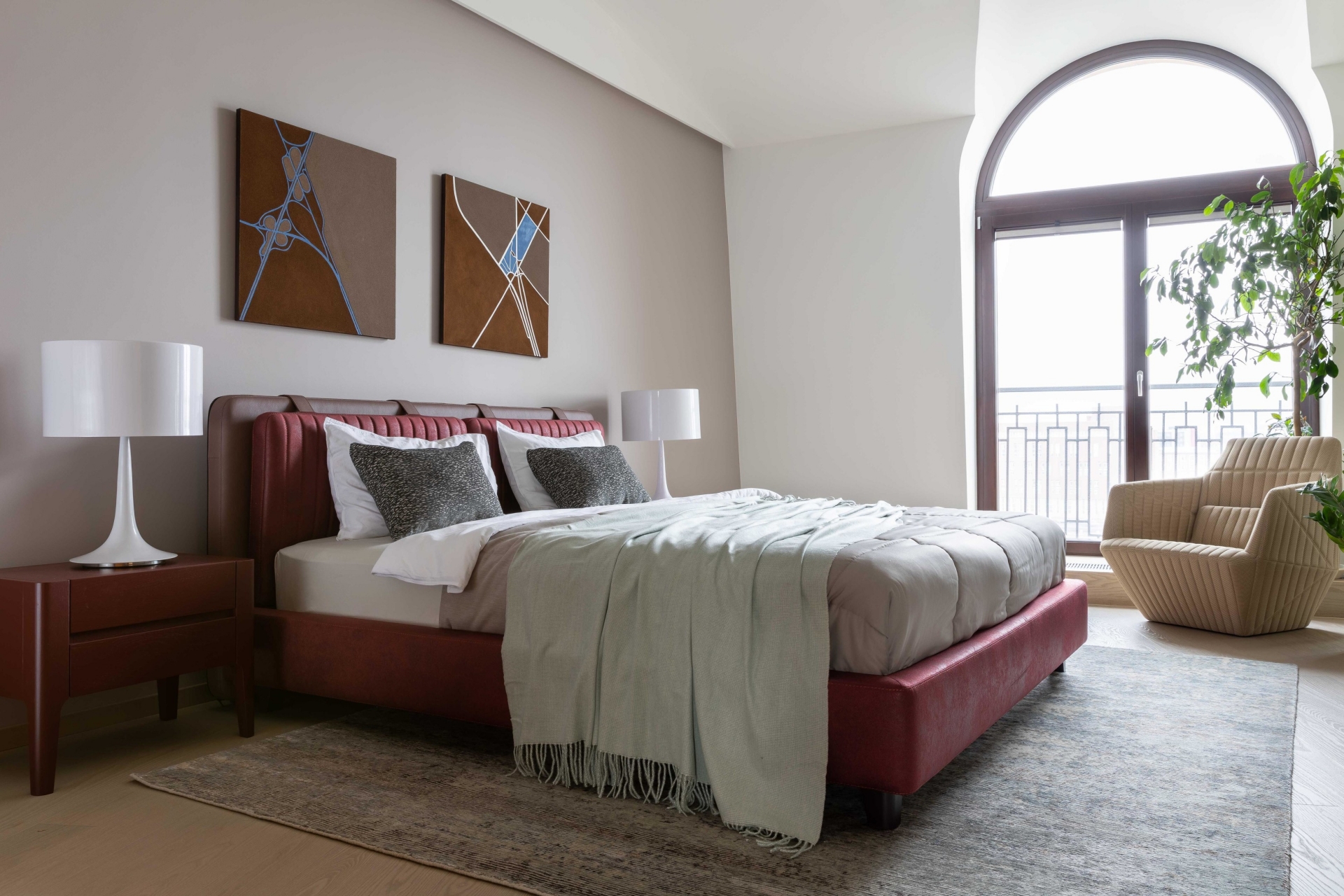 Phòng ngủ thứ hai không kém phần xinh đẹp với ô cửa sổ mái vòm cổ điển đón nhận trọn vẹn nguồn ánh sáng ấm áp. Những bức tranh của họa sĩ Elena Soroka được sử dụng để trang trí khu vực đầu giường. 