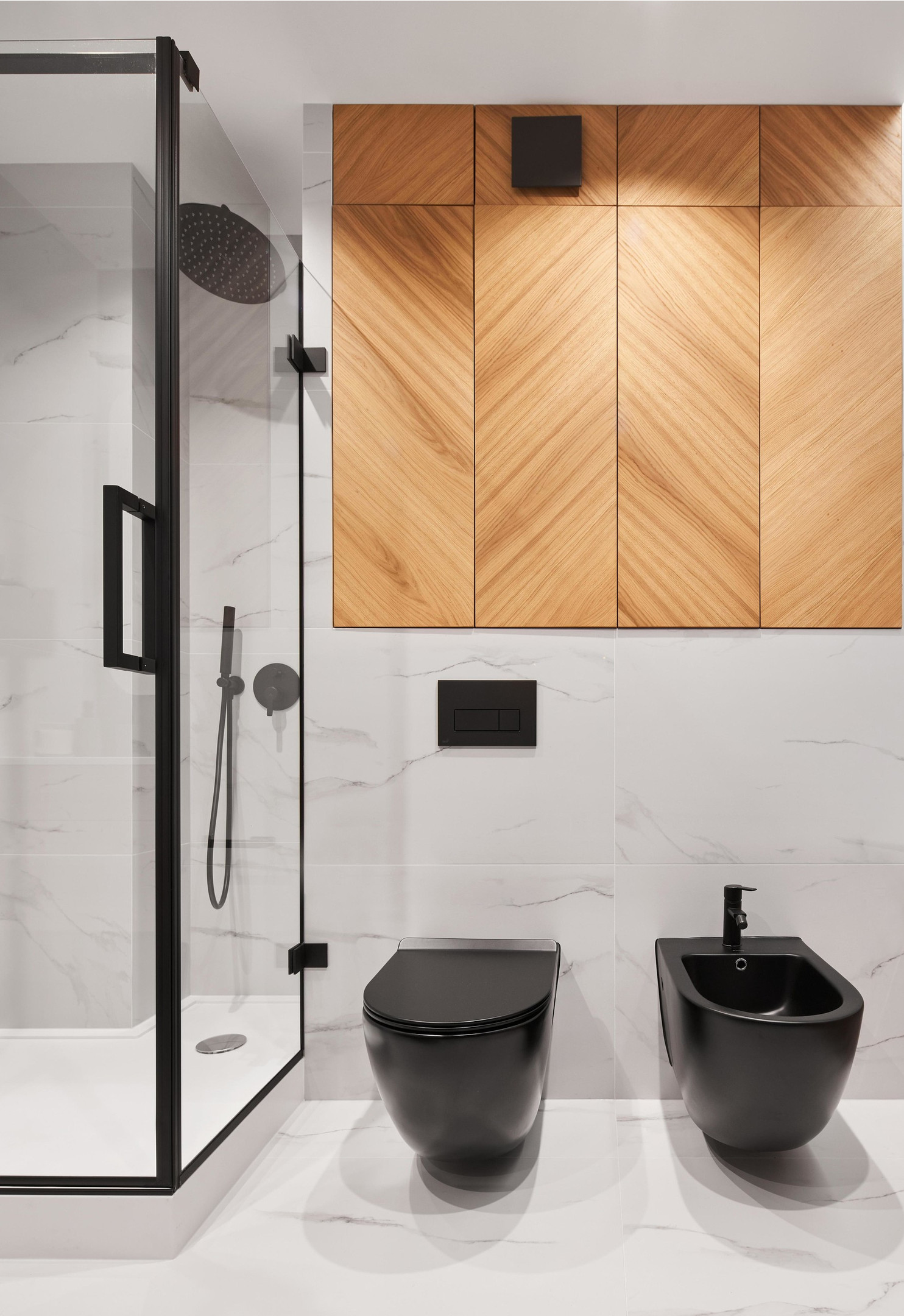 Phòng tắm và nhà vệ sinh của căn hộ được thiết kế '2 trong 1' với gam màu trắng - đen cổ điển, nhấn nhá sắc màu của vật liệu gỗ làm điểm nhấn trên sàn nhà và tường ốp đá cẩm thạch. 