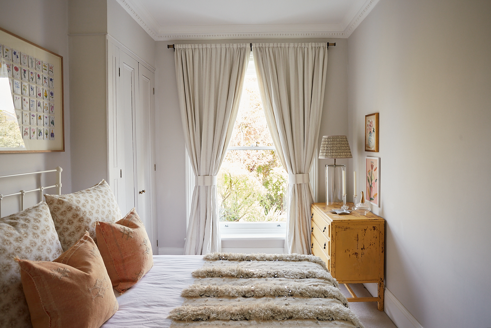Phòng ngủ thứ hai sử dụng sơn tường màu xám nhạt, trần màu trắng cùng những điểm nhấn màu cam gạch nổi bật. Căn phòng mang phong cách đồng quê, nhìn ra khung cửa sổ với cây cối bên ngoài cực kỳ lãng mạn.