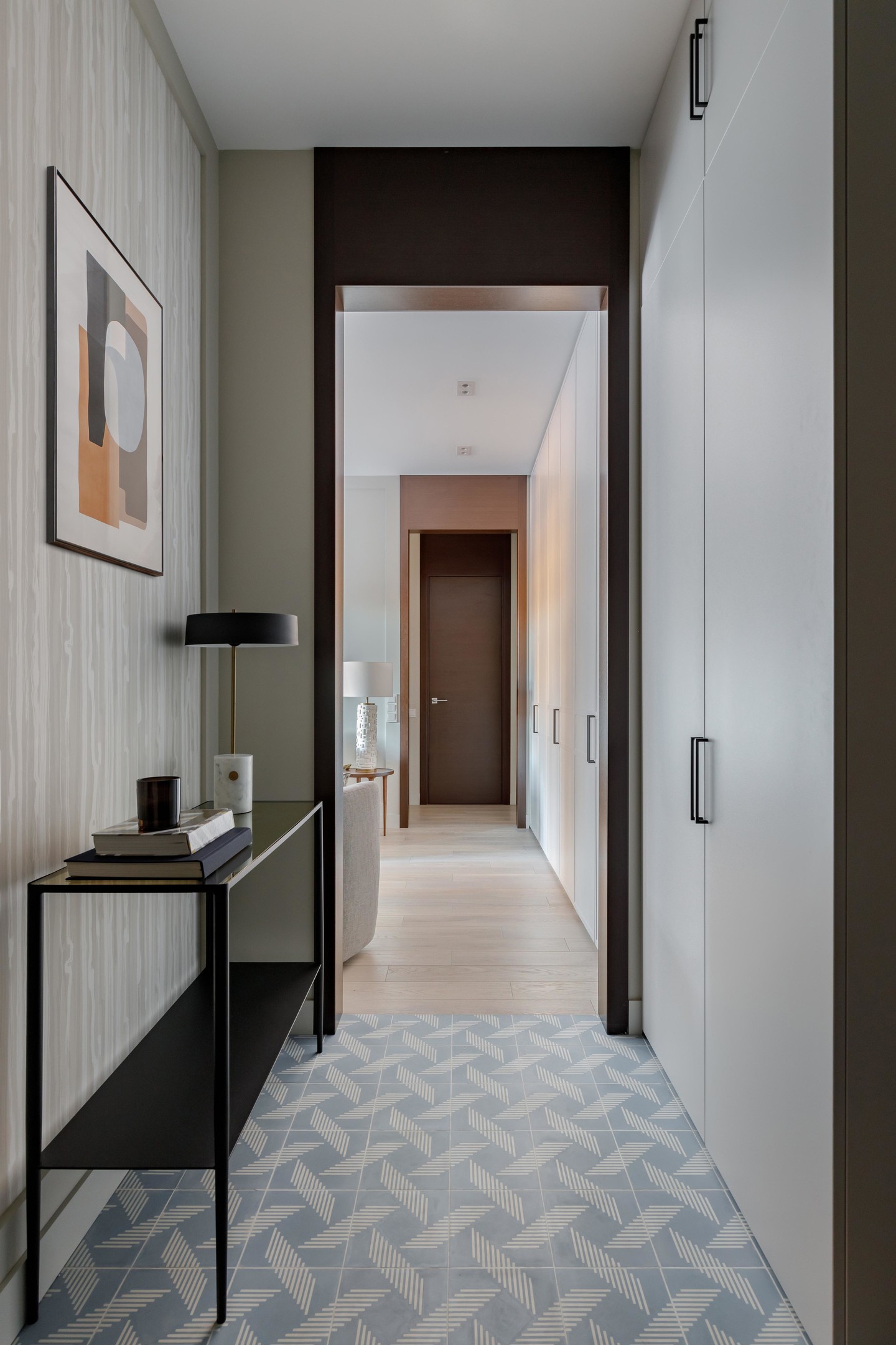 Tiền sảnh rộng lớn chiếm gần 1/4 căn hộ đã được Marina Novikova cải tạo lại để tăng diện tích cho phòng tắm và mở rộng đáng kể phòng khách. Sàn nhà lát gạch bông màu xanh lam và trắng, phân vùng với sàn gỗ của khu vực sinh hoạt chung.