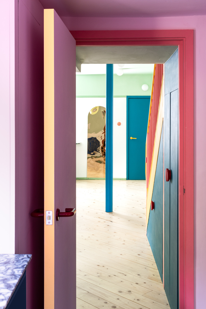 Hai bức hình thể hiện các góc chụp từ cửa lối ra vào và từ nhà vệ sinh ở tầng trệt. Nếu các không gian sinh hoạt chung lựa chọn những gam màu như hồng, xanh lá, xanh lam, vàng,... thì tại khu vực này đã xuất hiện một gam màu khác biệt hoàn toàn, đó là màu tím mộng mơ!