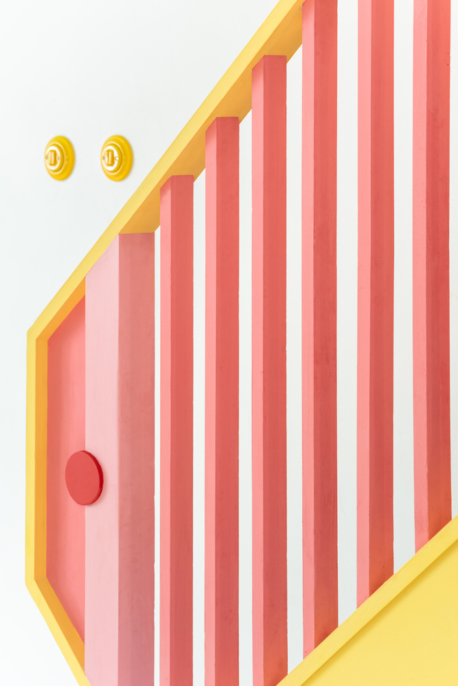 Lan can cầu thang sử dụng màu vàng trẻ trung cùng sắc hồng điệu đà để điểm tô nổi bật. Về tổng thể, ngôi nhà sử dụng các mảng màu (color) tạo thành khối (block) tạo nên phong cách Color block thu hút.