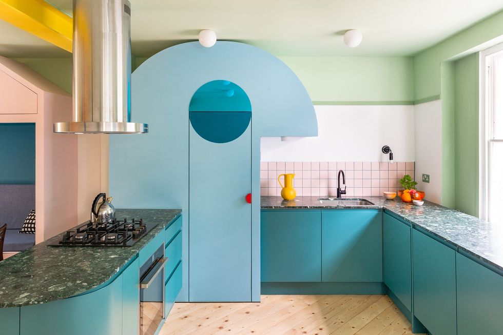 Phòng bếp nằm bên phải cửa ra vào với nhiều sắc màu như tường xanh bạc hà kết hợp màu trắng. Đặc biệt là hệ tủ bếp kiểu mái vòm màu xanh lam, trên mặt bàn ốp đá granite màu đen tạo sự vững chắc và dễ dàng vệ sinh cho không gian nấu nướng.