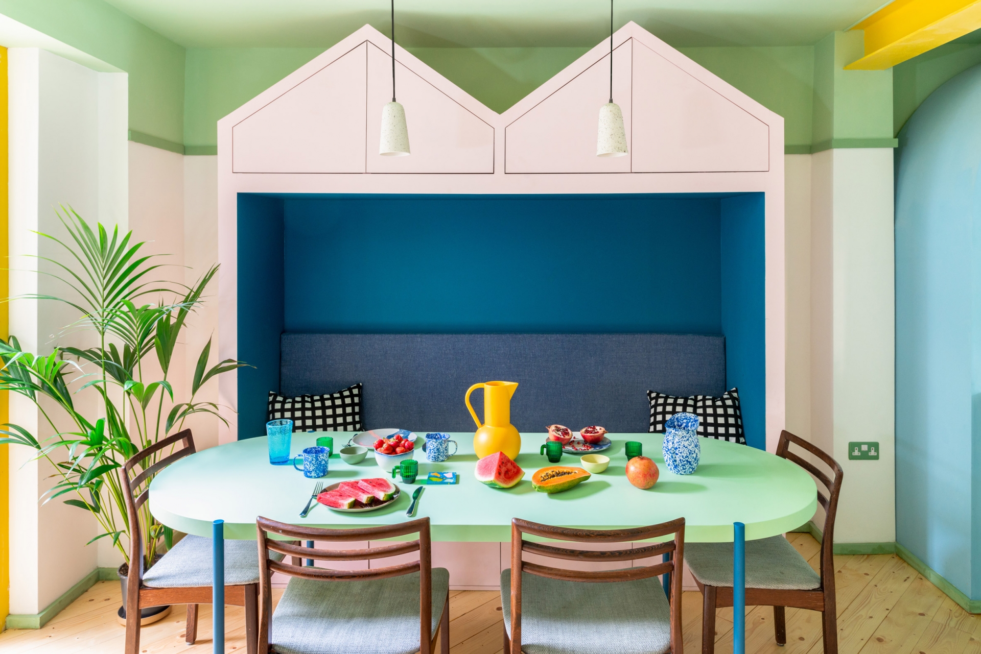 Kế bên phòng bếp là phòng ăn gia đình với thiết kế giống như kiểu dáng của những mái nhà  xinh đẹp. Chiếc bàn màu xanh bạc hà hình oval với những chiếc ghế xếp xung quanh cho cảm giác quây quần đầm ấm.