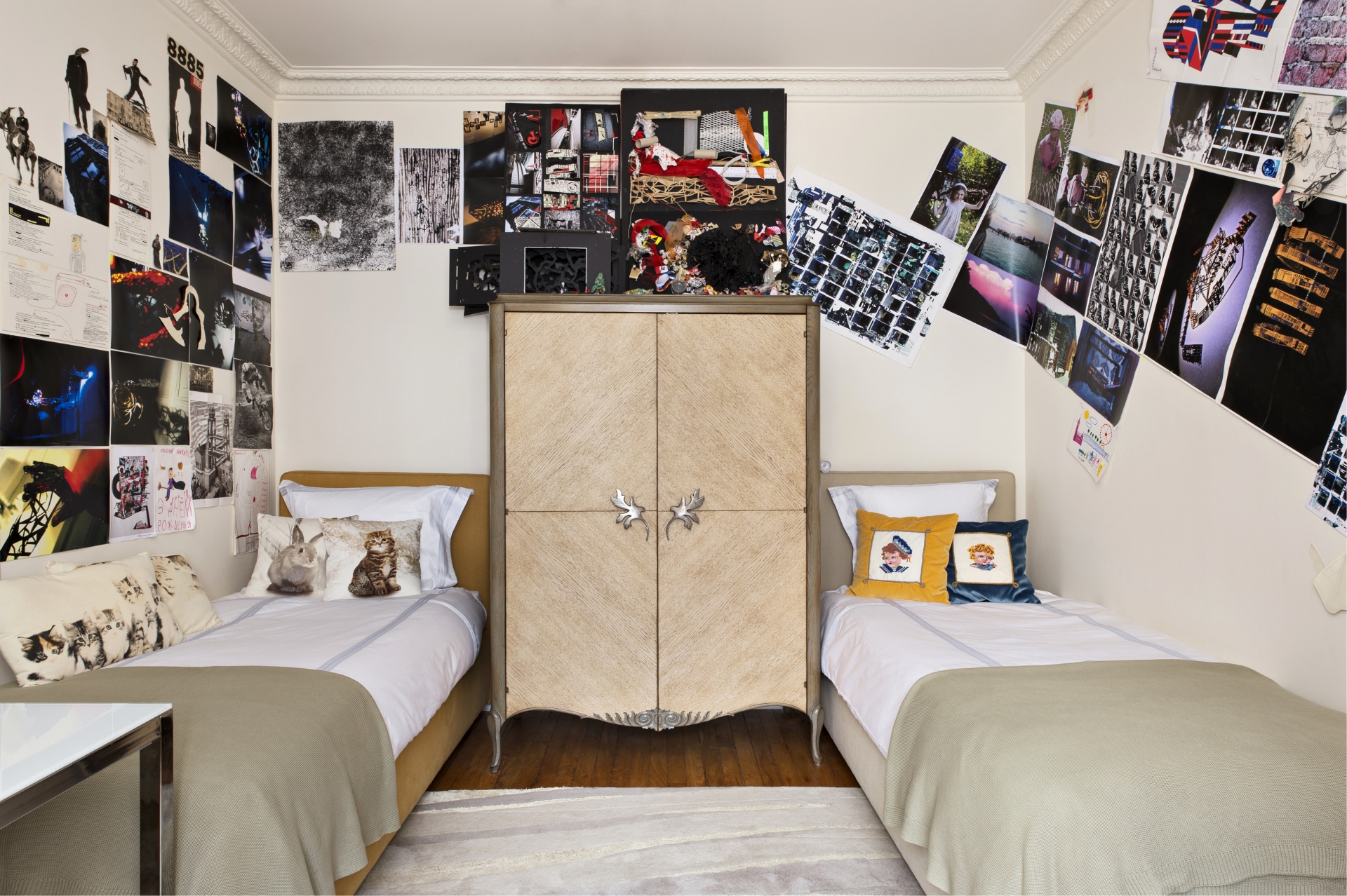 Phòng ngủ của hai anh em trai với 2 chiếc giường nhỏ bố trí đối xứng nhau, chính giữa là chiếc tủ lưu trữ kiểu dáng cổ điển. Những bức ảnh ghép trên tường là tác phẩm của nhà thiết kế đồ họa Nikita Sologubovsky.