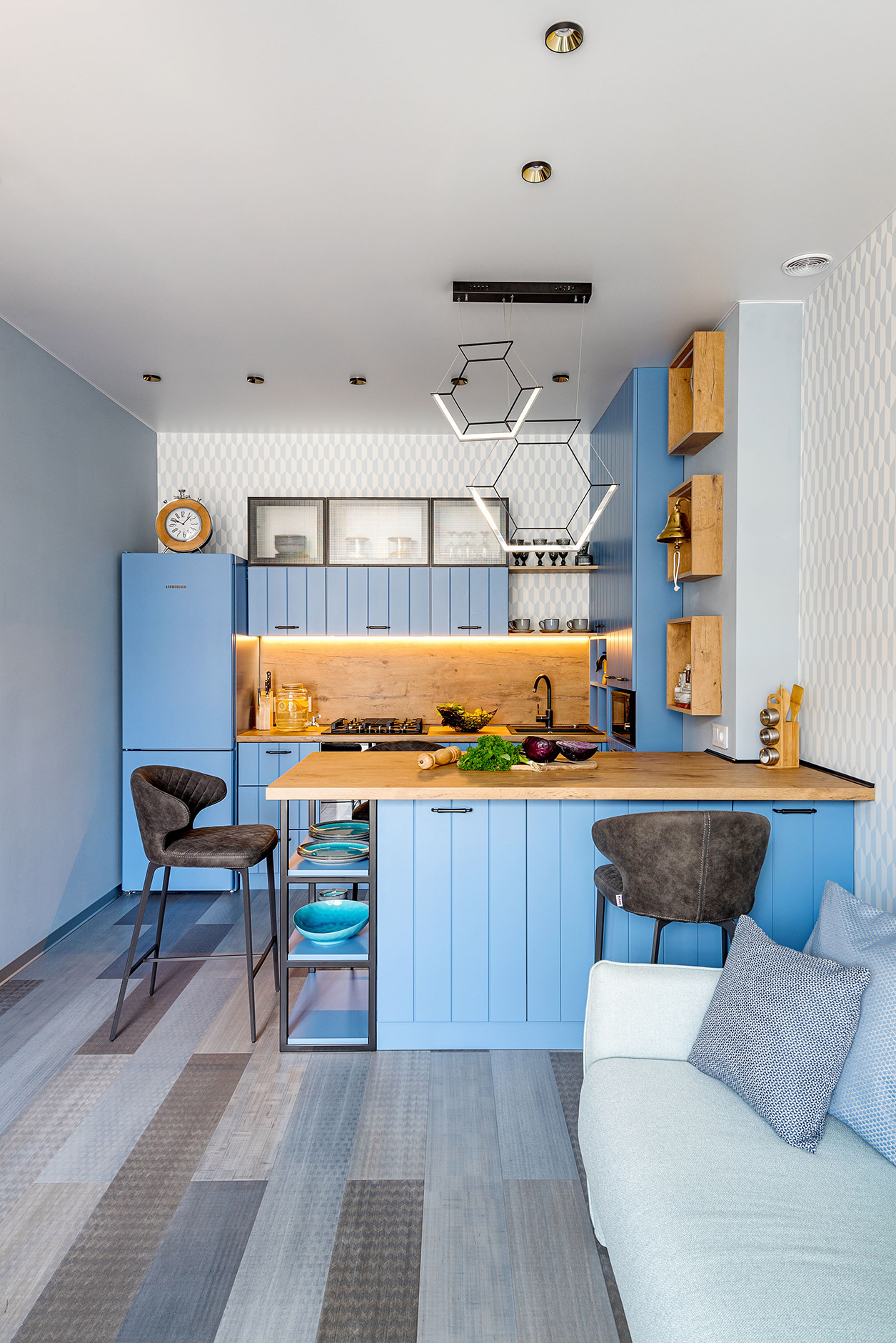 Phòng bếp này nằm trong căn hộ do nhà thiết kế Victoria Lazareva thực hiện, với tủ lưu trữ 3 ngăn mặt kính trong suốt, bố trí phía trên cùng của hệ thống tủ bếp màu xanh lam, tạo nên một cảm giác nhẹ nhàng, tươi sáng cho không gian nấu nướng.