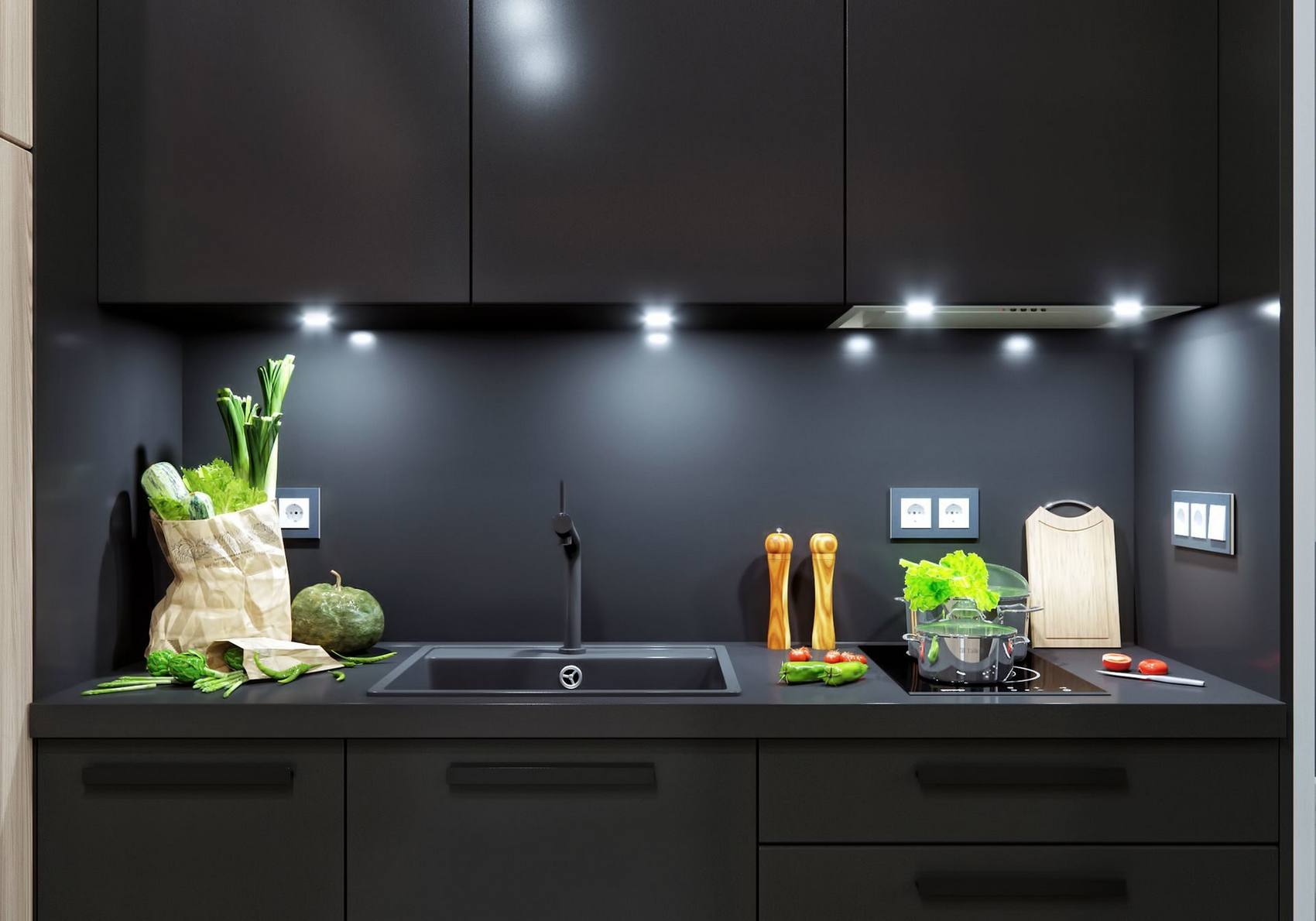 Tại khu vực nấu nướng, toàn bộ hệ thống tủ lưu trữ trên và dưới, cả backsplash đều sử dụng duy nhất tone màu đen. Lựa chọn này không chỉ đi theo gam màu chủ đạo của căn hộ mà còn giúp bếp luôn sạch sẽ, thể hiện vẻ nam tính, đồng thời NTK cũng tích hợp đèn gầm để tăng cường ánh sáng cho khu vực này.