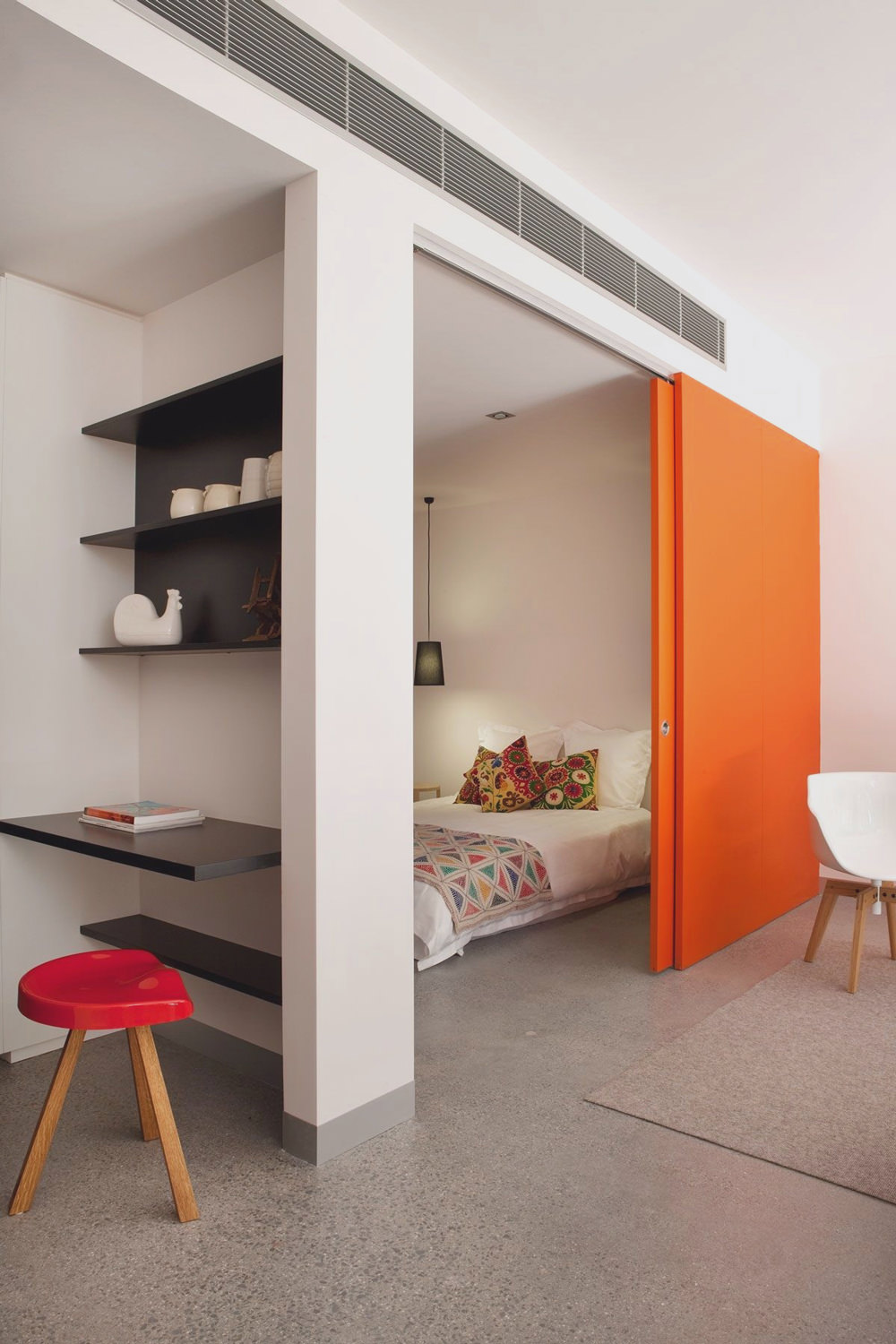  Cửa trượt màu cam nổi bật không chỉ tạo sự riêng tư tuyệt đối mà còn là điểm nhấn cho phòng ngủ giữa không gian ngập tràn sắc trắng.