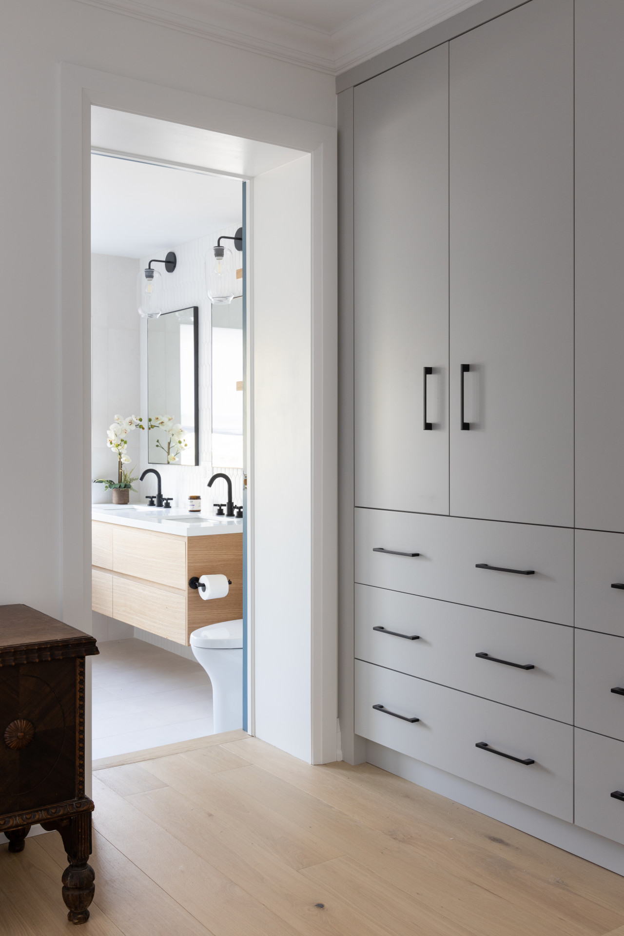 Bên ngoài phòng tắm là tủ lưu trữ màu xám với kích thước kịch trần để tận dụng chiều cao và tối ưu hóa không gian lưu trữ.