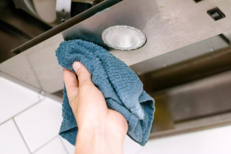 Nhúng giẻ lau vào nước ấm và chà rửa lại một lần nữa để bên trong máy hút mùi được sạch sẽ hoàn toàn.
