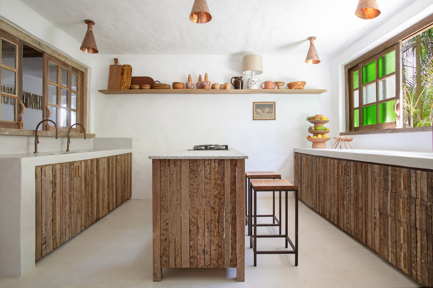 Trong nhà bếp, việc lắp đặt một đảo bếp đã tối ưu hóa không gian và giúp nhân rộng khu vực làm việc và ăn uống. Những ô cửa sổ duyên dáng với kính màu xanh lá chuối. 