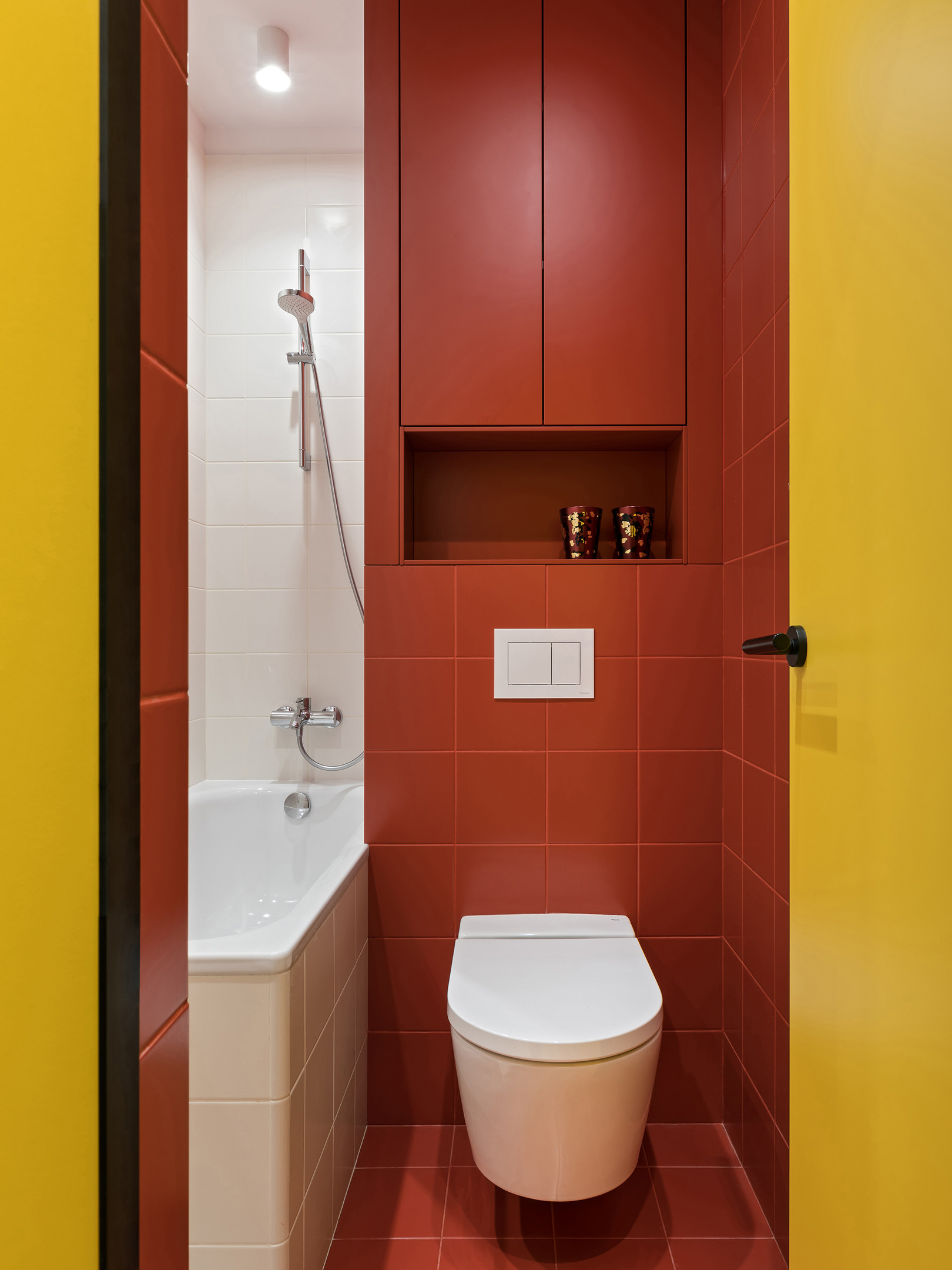 Gạch ô vuông cùng màu sơn đỏ mận được dùng để ốp lát tường và sàn nhà vệ sinh. Riêng toilet và bồn tắm nằm chọn vật liệu sứ màu trắng cho cảm giác sạch sẽ, thanh lịch, trung hoà sắc đỏ có phần quá nổi bật. Chỉ trong một không gian siêu nhỏ vài mét vuông nhưng công trình vệ sinh thực sự lôi cuốn người nhìn chỉ bằng màu sắc!