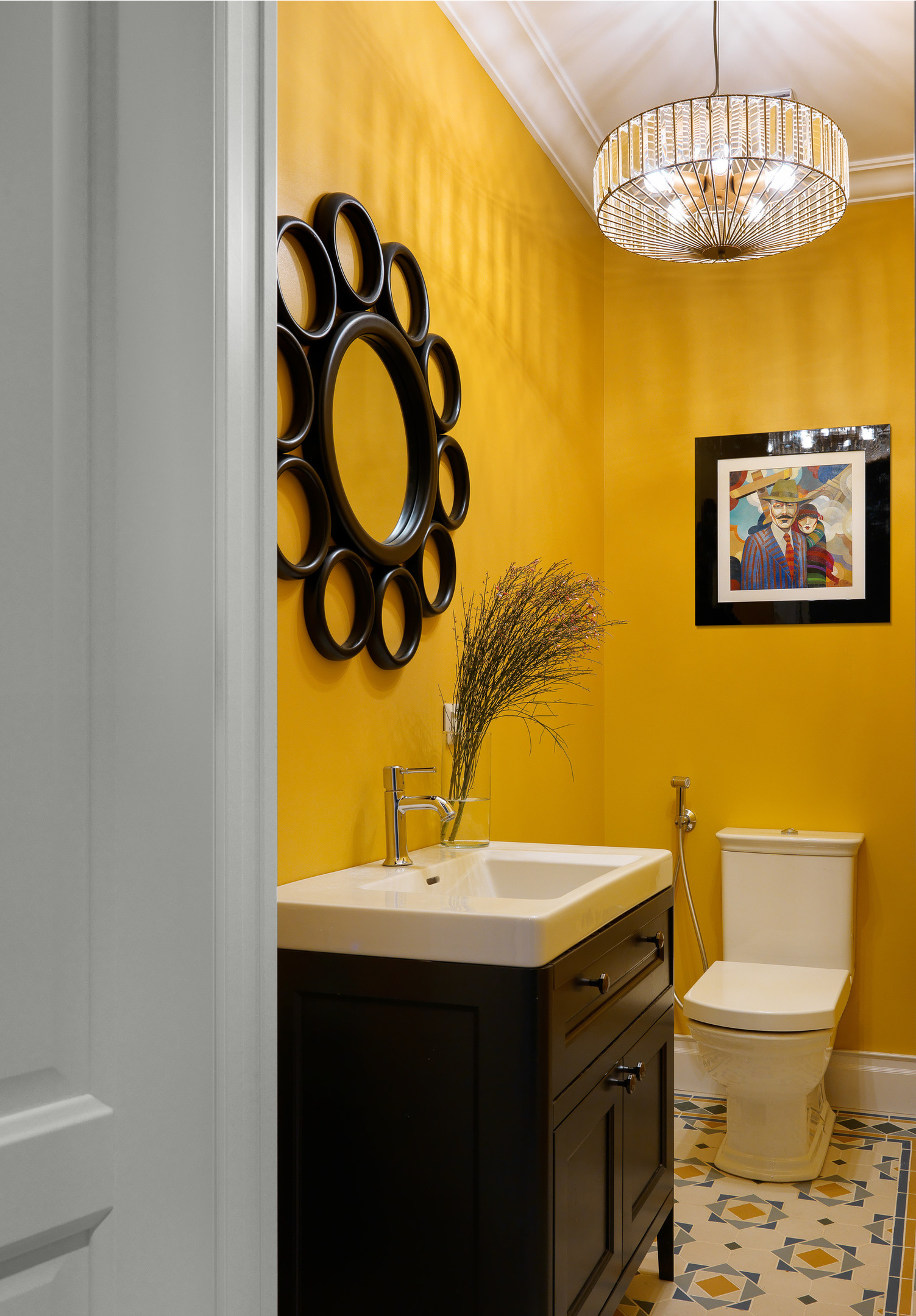 Dự án của NTK Marina Braginskaya mang đến cho phòng tắm vẻ đẹp như một gallery nghệ thuật. Từ gương treo tường, tranh ảnh,...  đến chiếc đèn chùm pha lê tinh xảo, phản chiếu ánh sáng tuyệt đẹp trên phông nền màu vàng vừa rực rỡ vừa ấm cúng.