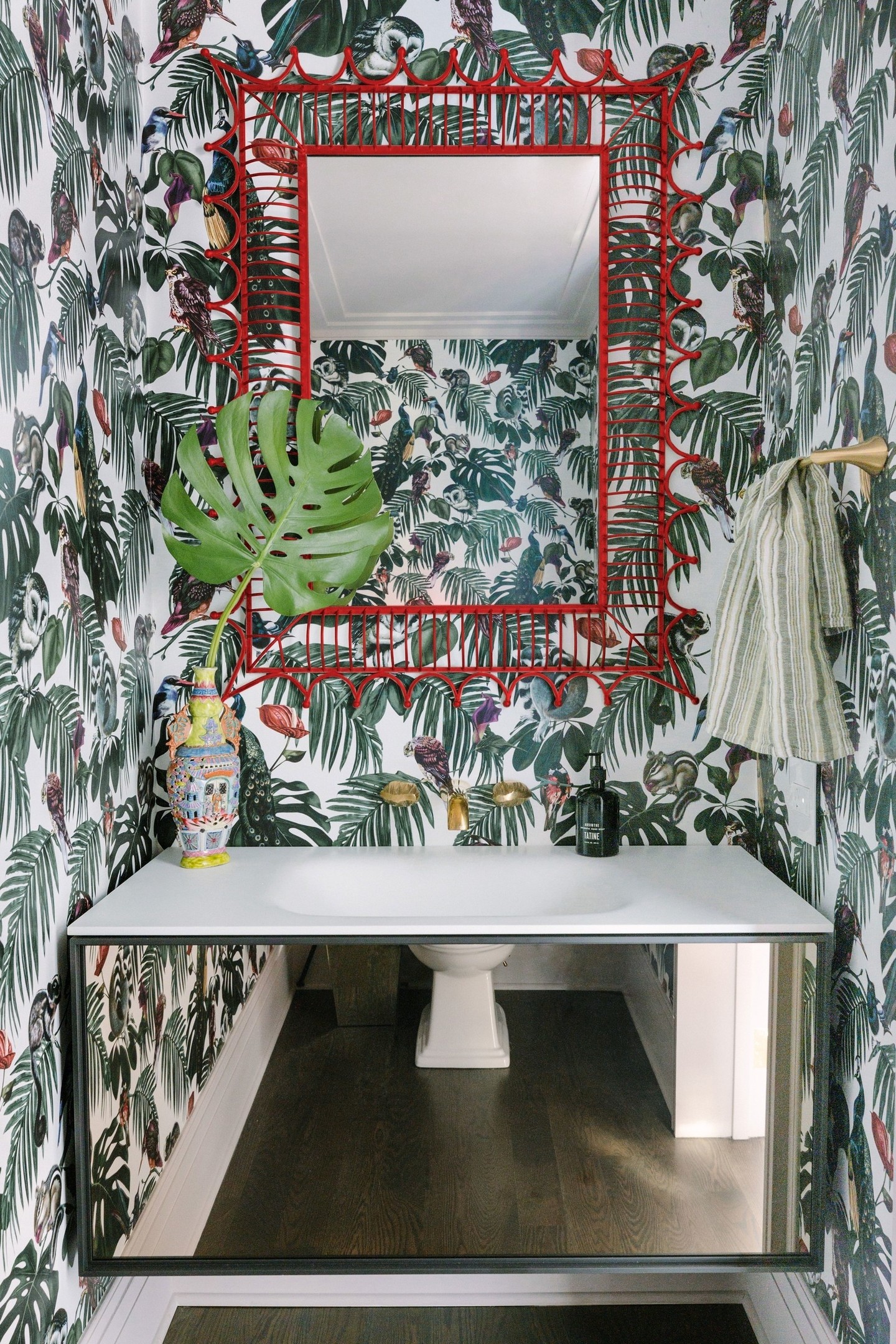 Phòng tắm nằm trong căn hộ ở thành phố Chicago (Hoa Kỳ) do CAK Studio thiết kế. Bằng việc lựa chọn giấy dán tường cho đến lọ hoa trang trí thì tấm gương với viền khung màu đỏ cũng là điểm nhấn độc đáo cho không gian thêm quyến rũ.