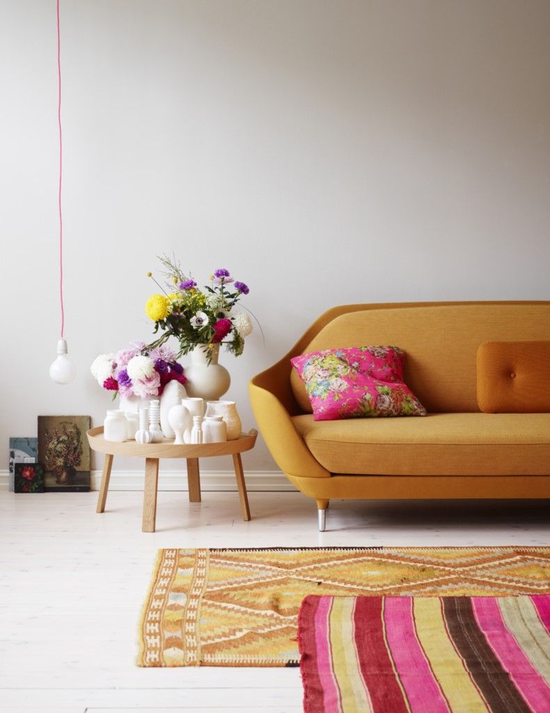 Không gian được thiết kế trang nhã và tinh tế, từ cách lựa chọn nội thất cho đến màu sắc trang trí. Ghế sofa màu cam gạch, gối bọc vải hoa văn màu hồng điệu đà, kết hợp với vẻ đẹp của 2 tấm thảm trải sàn 'tone sur tone' cho cái nhìn hài hòa đẹp mắt.