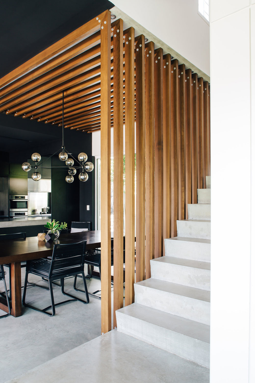Ngôi nhà sử dụng gỗ tự nhiên sắc màu tuyệt đẹp, vừa tương phản với màu đen trong phòng bếp vừa hài hòa với những bậc tam cấp màu trắng của cầu thang. Những thanh gỗ bao phủ từ trần nhà đồng thời thay thế lan can cho cái nhìn đẹp mắt, cá tính.