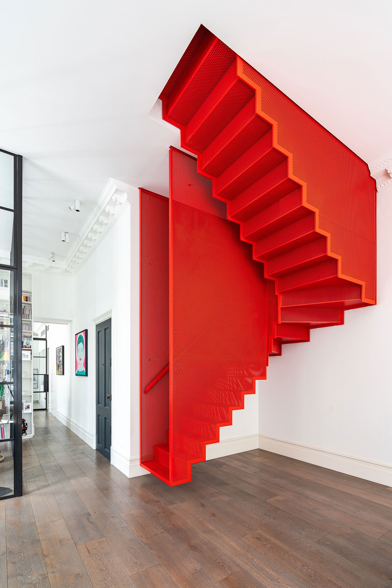 Trung tâm của căn hộ là chiếc cầu thang màu đỏ tươi lấy cảm hứng từ tác phẩm nghệ thuật Staircase-III của nghệ sĩ sắp đặt người Hàn Quốc, Doh Ho Suh, với vật liệu kim loại đục lỗ nhằm tạo cảm giác thoáng sáng.