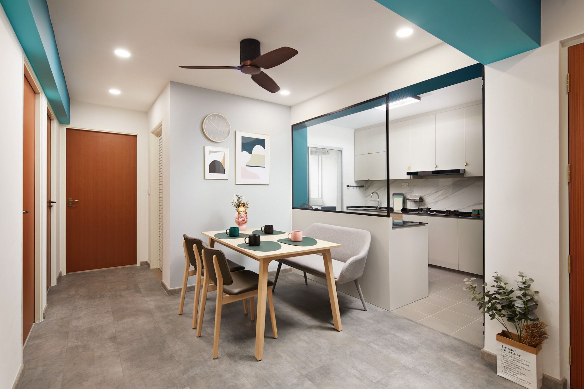 Phòng bếp nhỏ thiết kế đơn giản, nội thất gọn gàng, liên kết với khu vực bên ngoài bằng điểm nhấn màu xanh ngọc lam đẹp mắt. Ngoài ra, bức tường kính phía trên cũng giúp phân vùng nhưng vẫn tạo được thông thoáng nhất định.