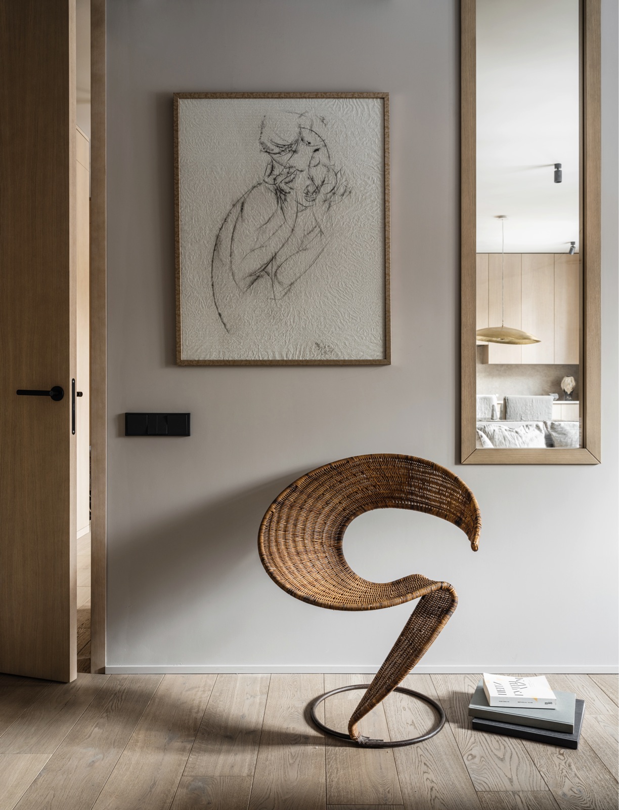 Đối diện giường ngủ, một chiếc ghế cổ điển kiểu dáng độc đáo bằng mây tre đan với chân kim loại hình tròn. Trên tường là một tác phẩm của Nalbi Bugashev, tác giả bức tranh ở hành lang lối vào. Một cửa kính viền khung gỗ hình chữ nhật dọc tường cho phép chủ nhân nhìn ra khu vực sinh hoạt chung từ trong phòng ngủ.