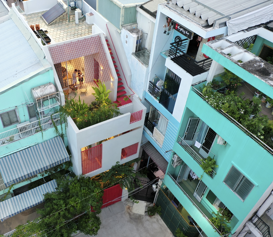 Từ trên cao nhìn xuống, ngôi nhà với điểm nhấn màu đỏ nổi bật trong một con hẻm tại quận 5, TP. Hồ Chí Minh.
