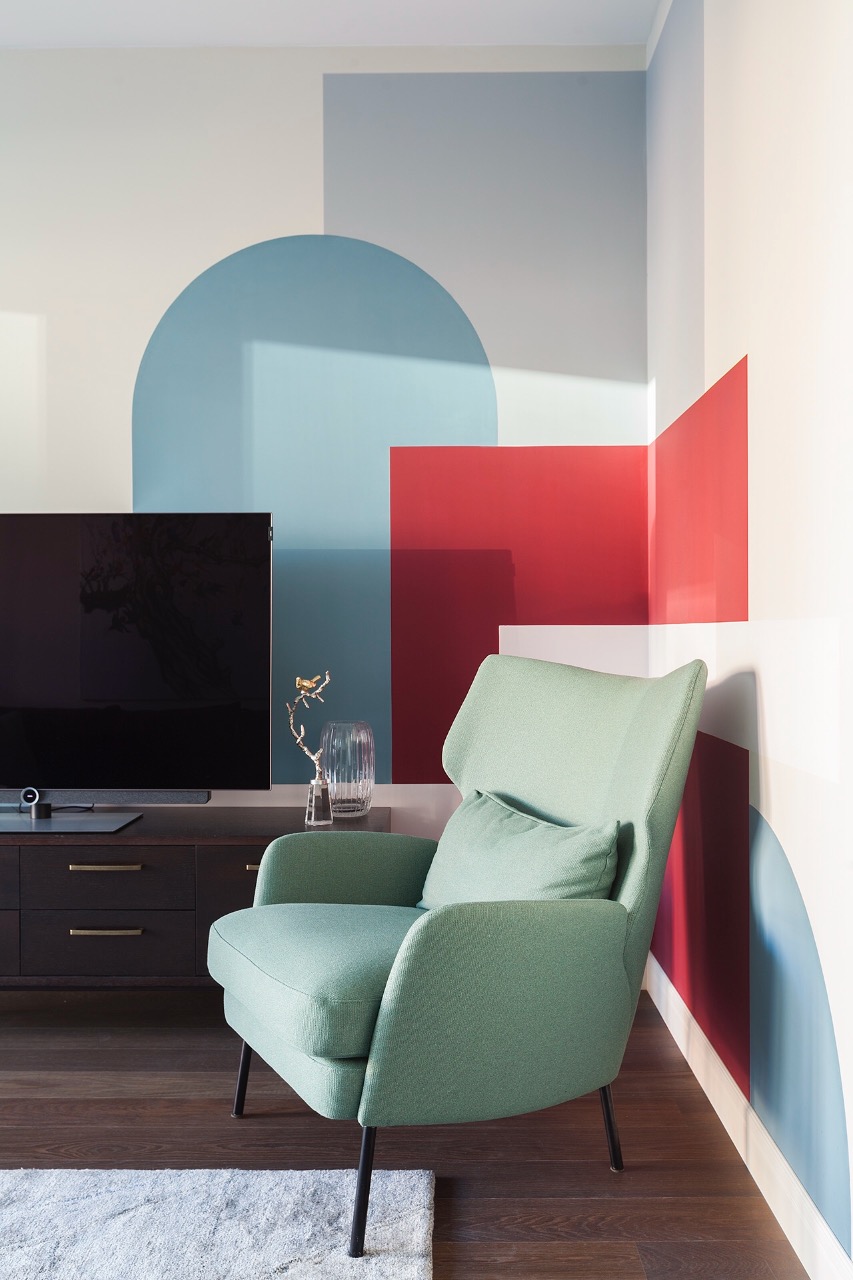 Nếu muốn thêm màu sắc nổi bật giữa tone pastel thì bạn có thể chọn phong cách colour block như cách mà NTK nội thất sử dụng cho phòng khách này. Mảng tường đa sắc trở thành phông nền tuyệt vời cho chiếc ghế bành màu xanh bạc hà tỏa sáng.
