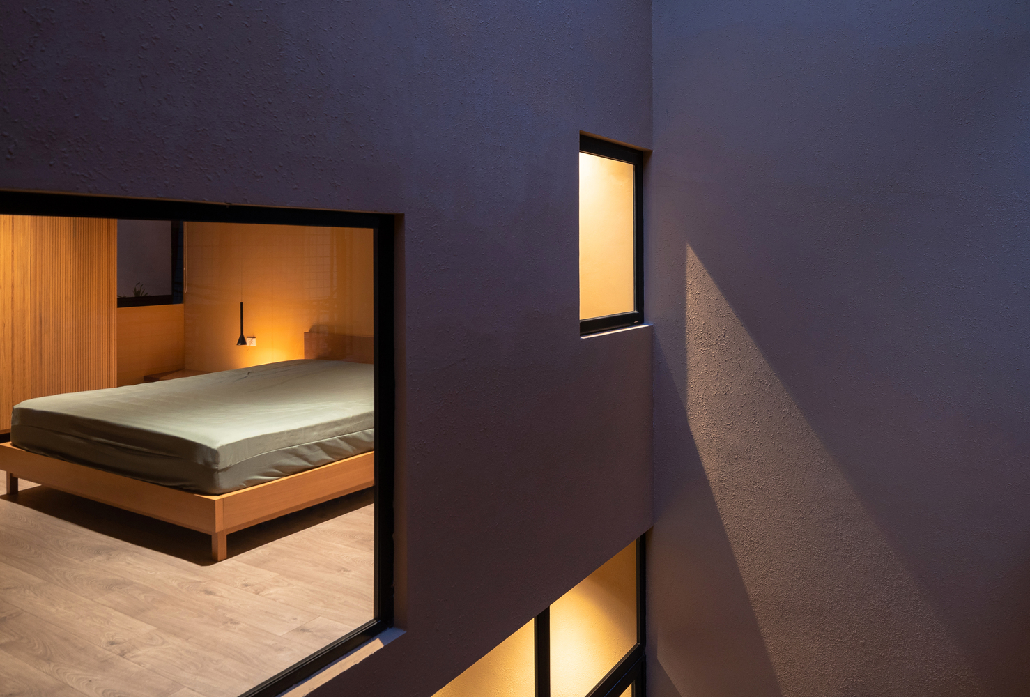 Phòng ngủ thiết kế đơn giản với nội thất cơ bản như giường ngủ, táp đầu giường, đèn gắn tường và tủ quần áo chiều cao kịch trần nhằm tối ưu hóa không gian.